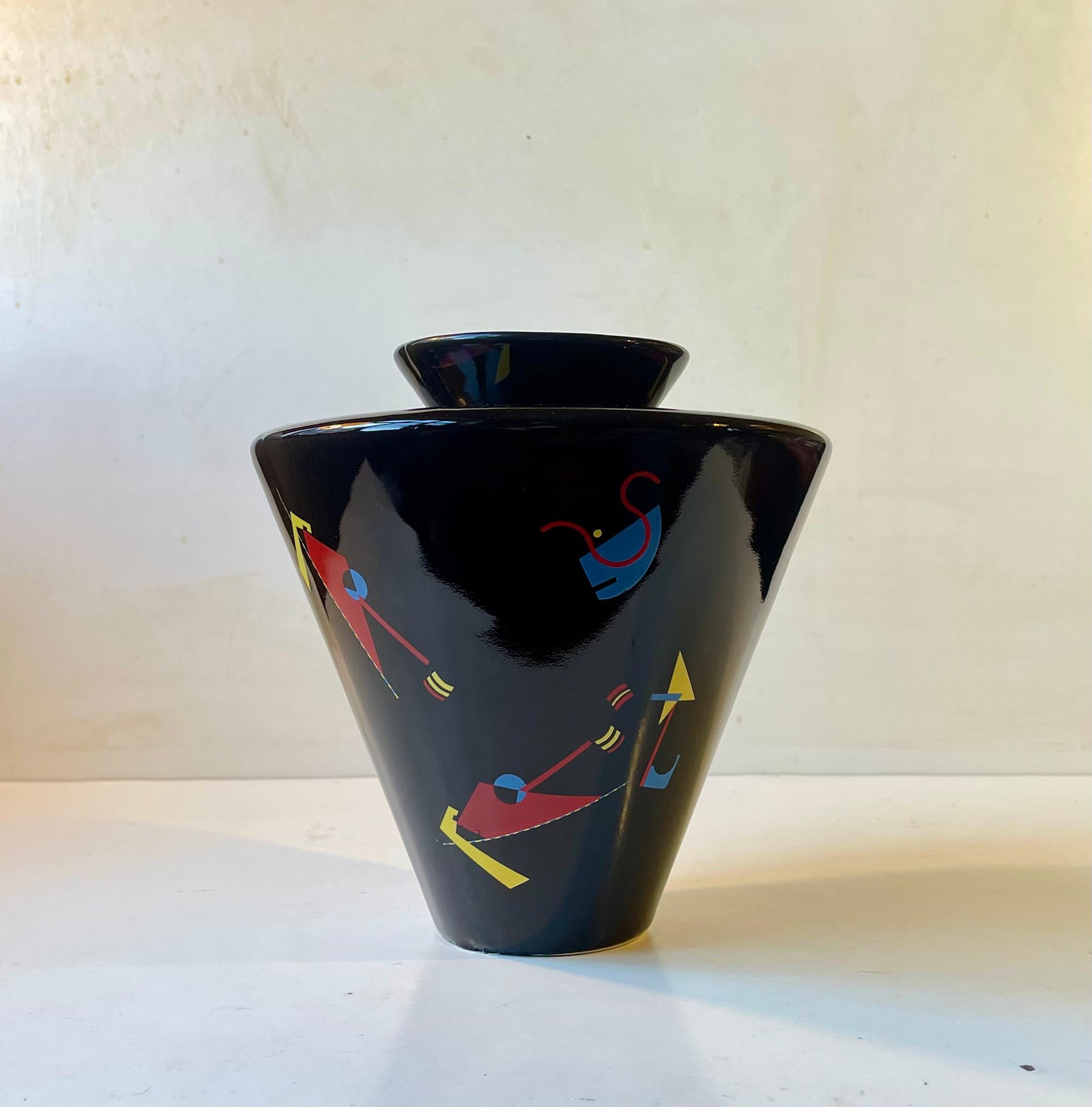 Exceptional spinner-shaped vase in glazed black porcelain. It features colorful geometric expression very much so in the style of the Godfather of Abstract epressionism Wassily Kardinski. The color palette however is more derivative of Joan Miro.