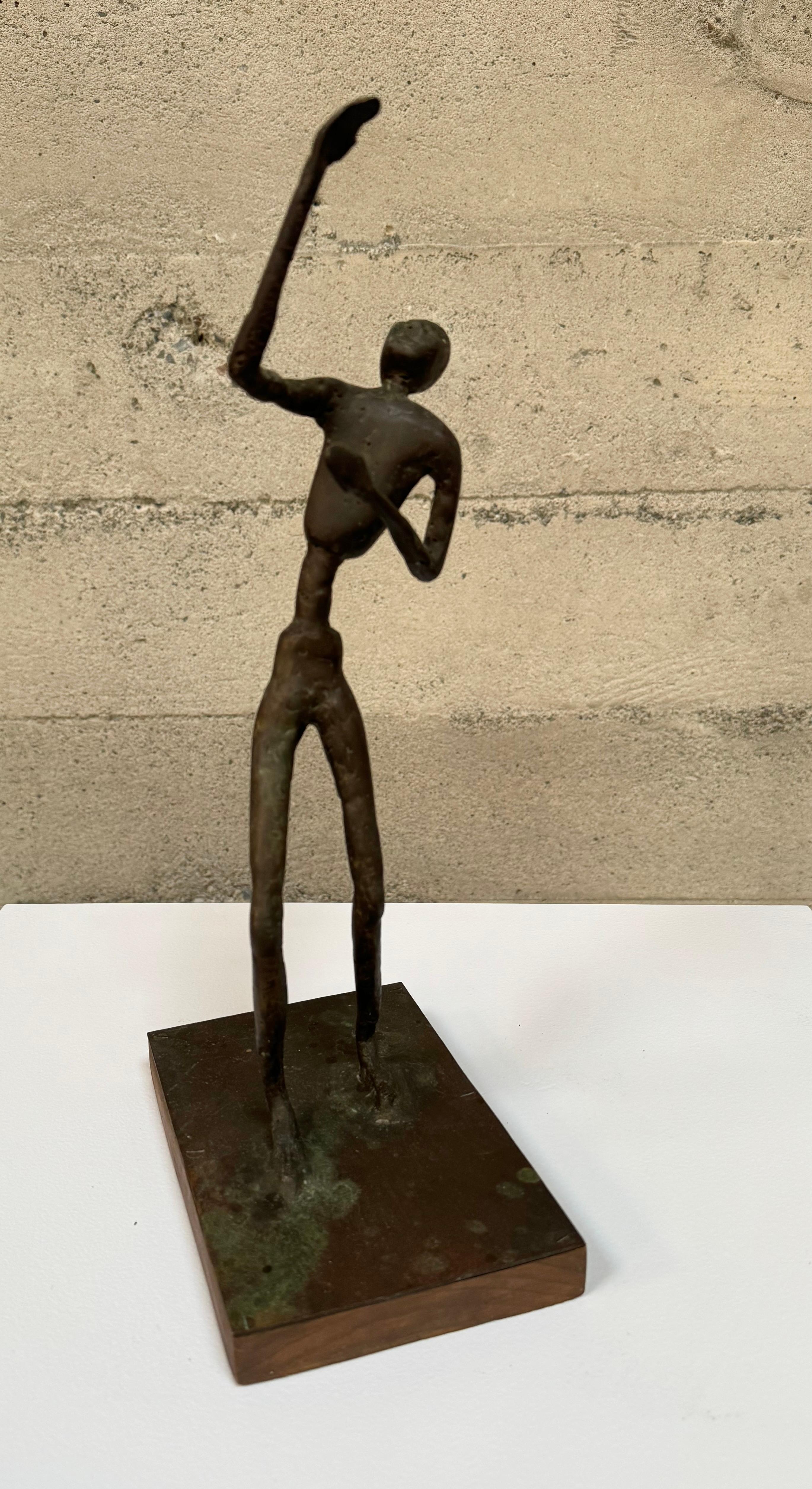An expressive figurative abstract by Bay Area artist John Larkin, he was a local artist who was active in the 1960s but little is known about the artist. A thin figure done in a textured bronze mounted on a wooden base. The sculpture has developed a