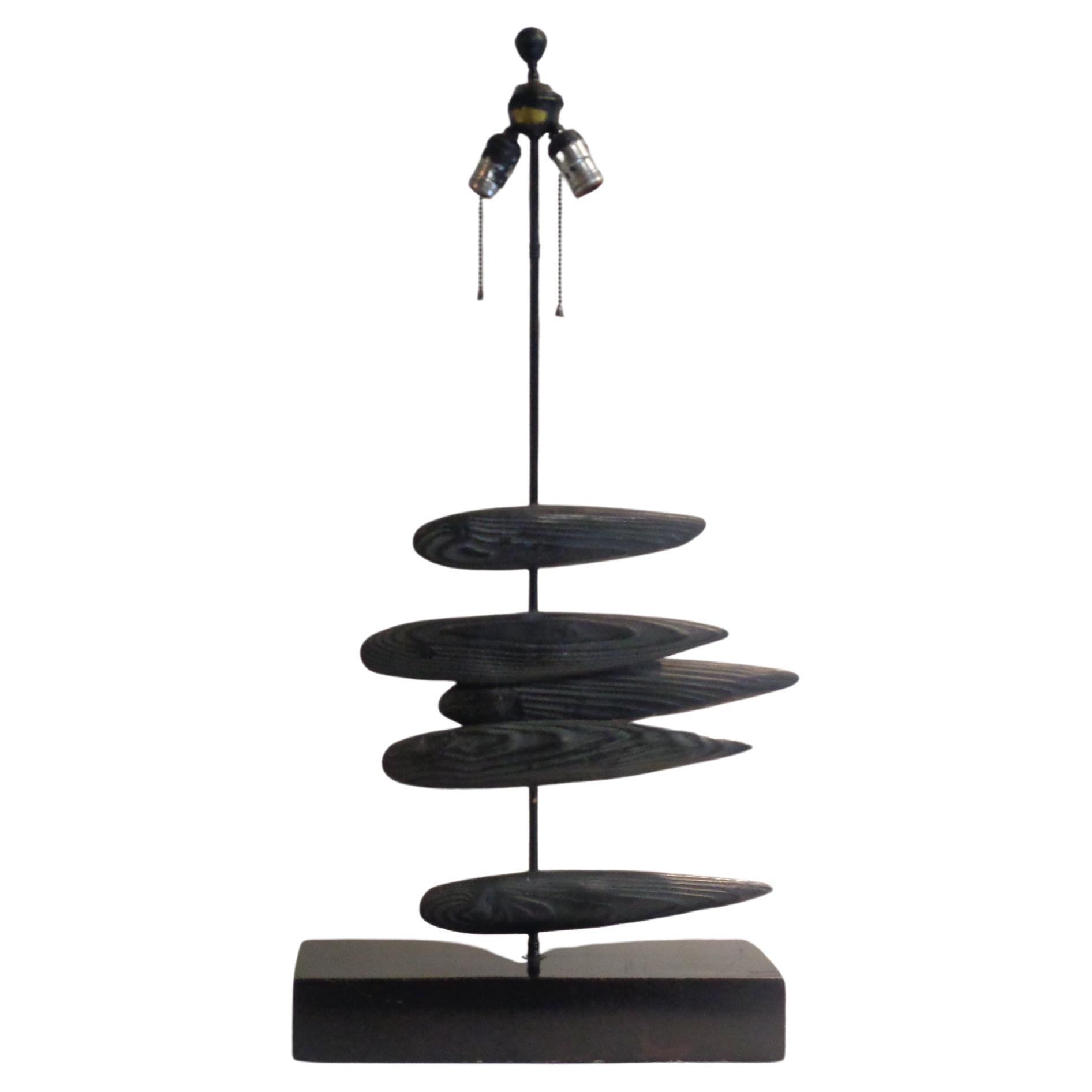Mid 20th century abstract fish sculpture table lamp. Five black cerused faux driftwood fishes bisected by a central metal rod w/ a black lacquered rectangular wood base. Great looking. Look at all pictures and read condition report in comment