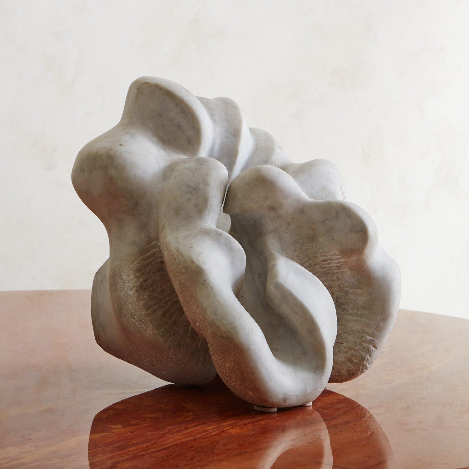 An abstract sculpture hand carved from a beautiful Statuarietto white marble with striking gray veining. We love the organic curves, freeform shape and textural details on this vintage beauty. Unsigned.
