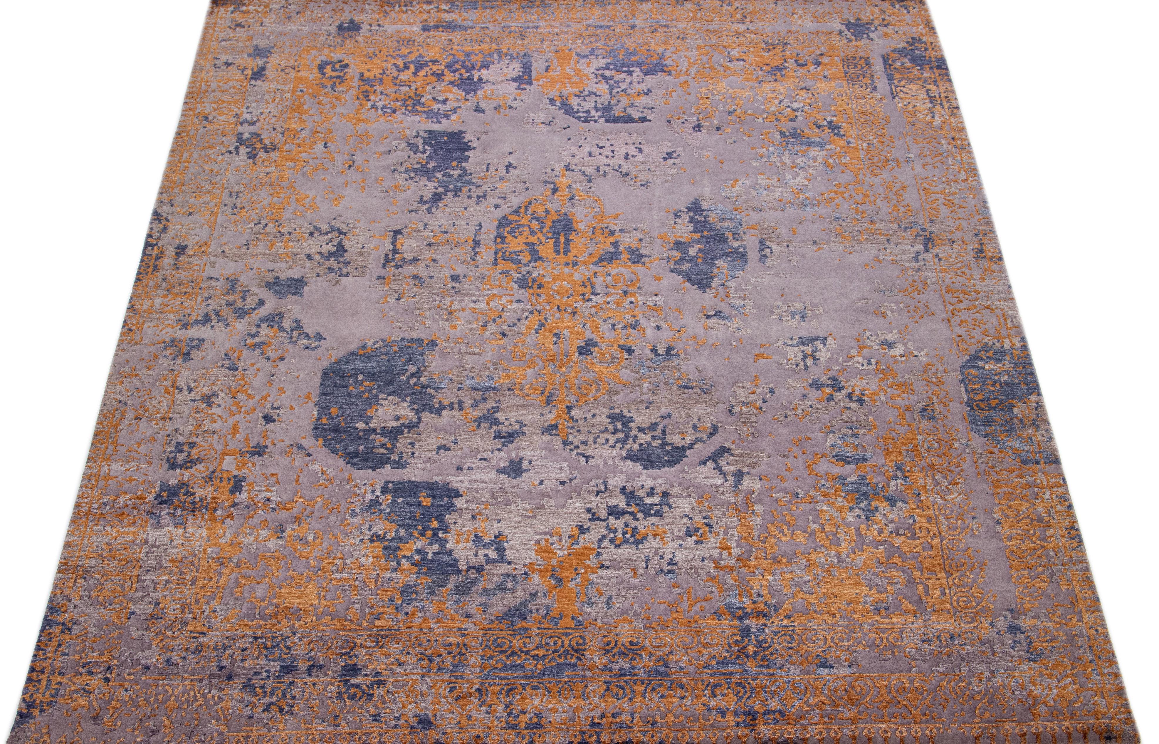 Beautiful modern Tibetan Indian wool & silk rug with the blue field in an abstract patterning purple and orange color. The wool and silk fibers provide a luxuriously soft feel, while its low pile height increases the rug's resilience, making it