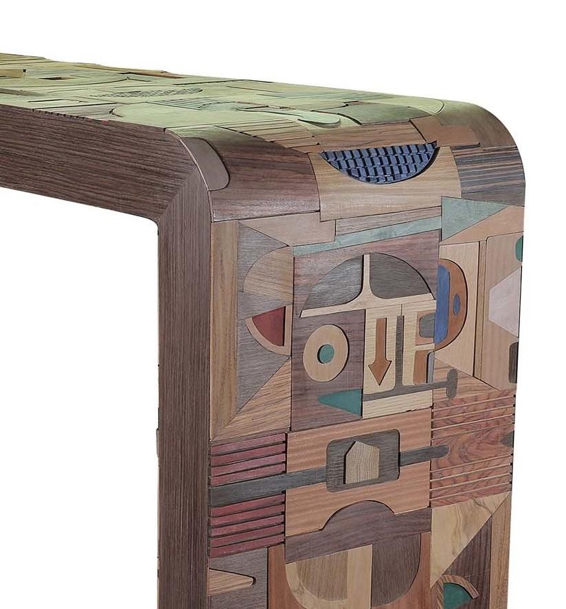 This work of art will enrich a living room with its singular design and dynamic decorations. Resting on four conical feet, the honeycomb wood structure bends on the sides to support the rectangular top. Every surface of the piece is superbly inlaid
