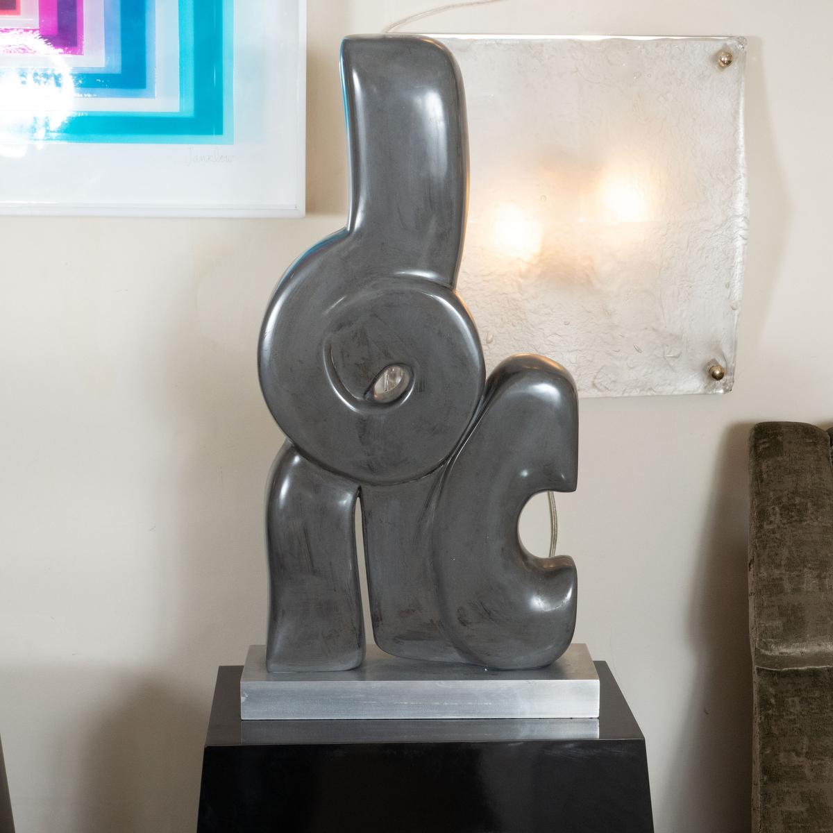 Abstract marble sculpture with black pedestal base. Signed H. Simon.