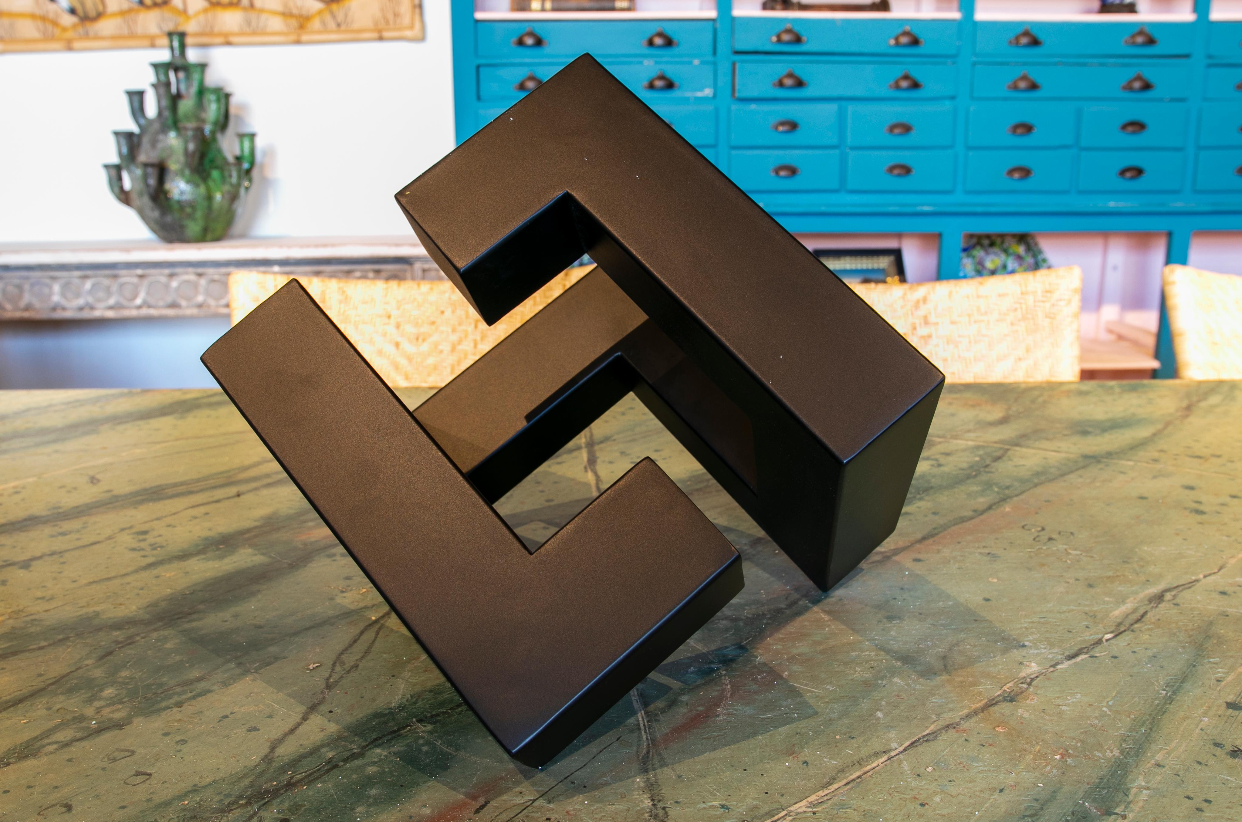 Abstract metal sculpture lacquered in orange with geometric forms.