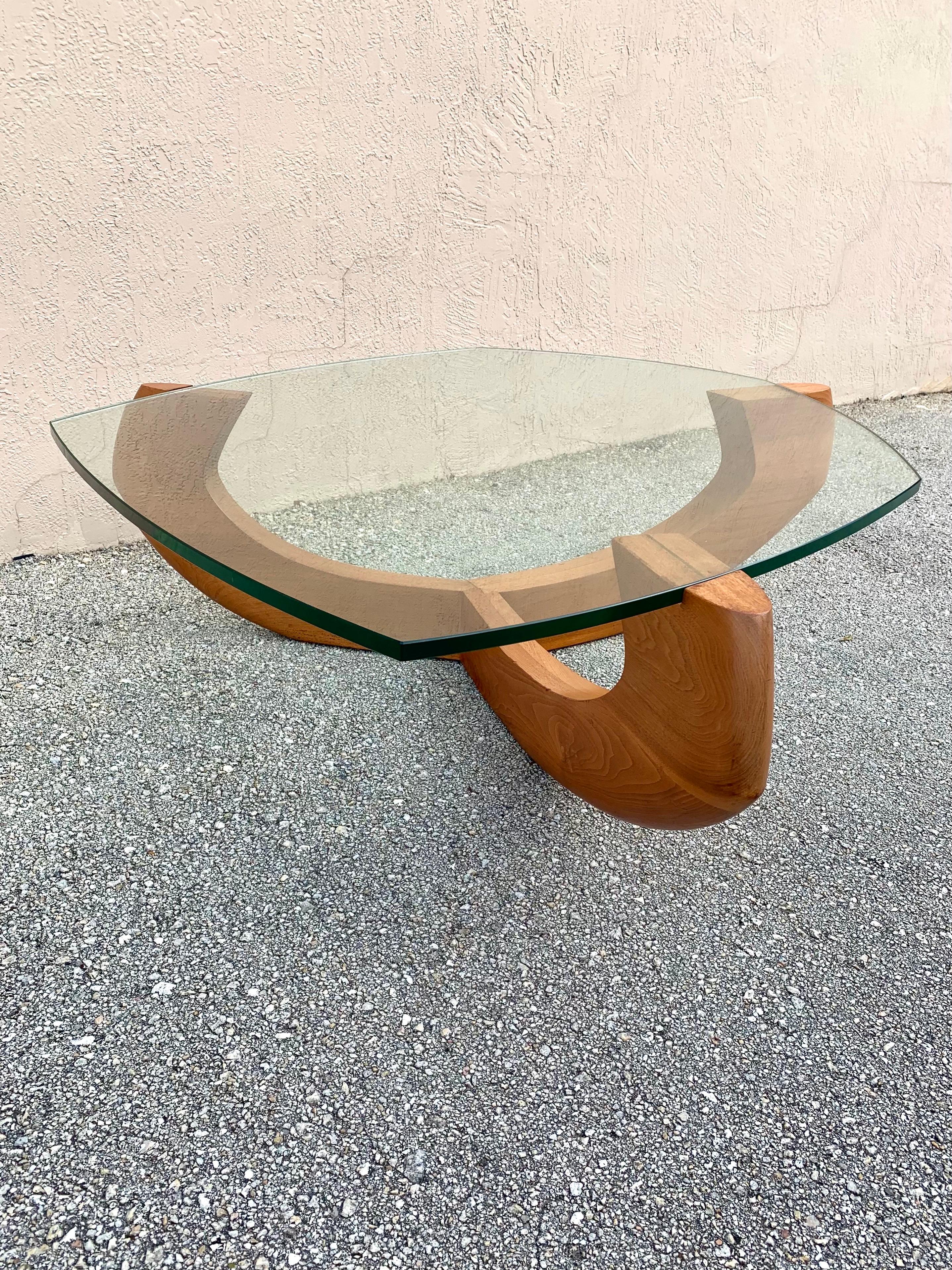 Mid Century Modern walnut glass top coffee table. Three solid arms coming from a tapered center holding up the glass top. Each arm has a brass stripe accenting under the glass top. Each different angle creates its own unique and interesting view.