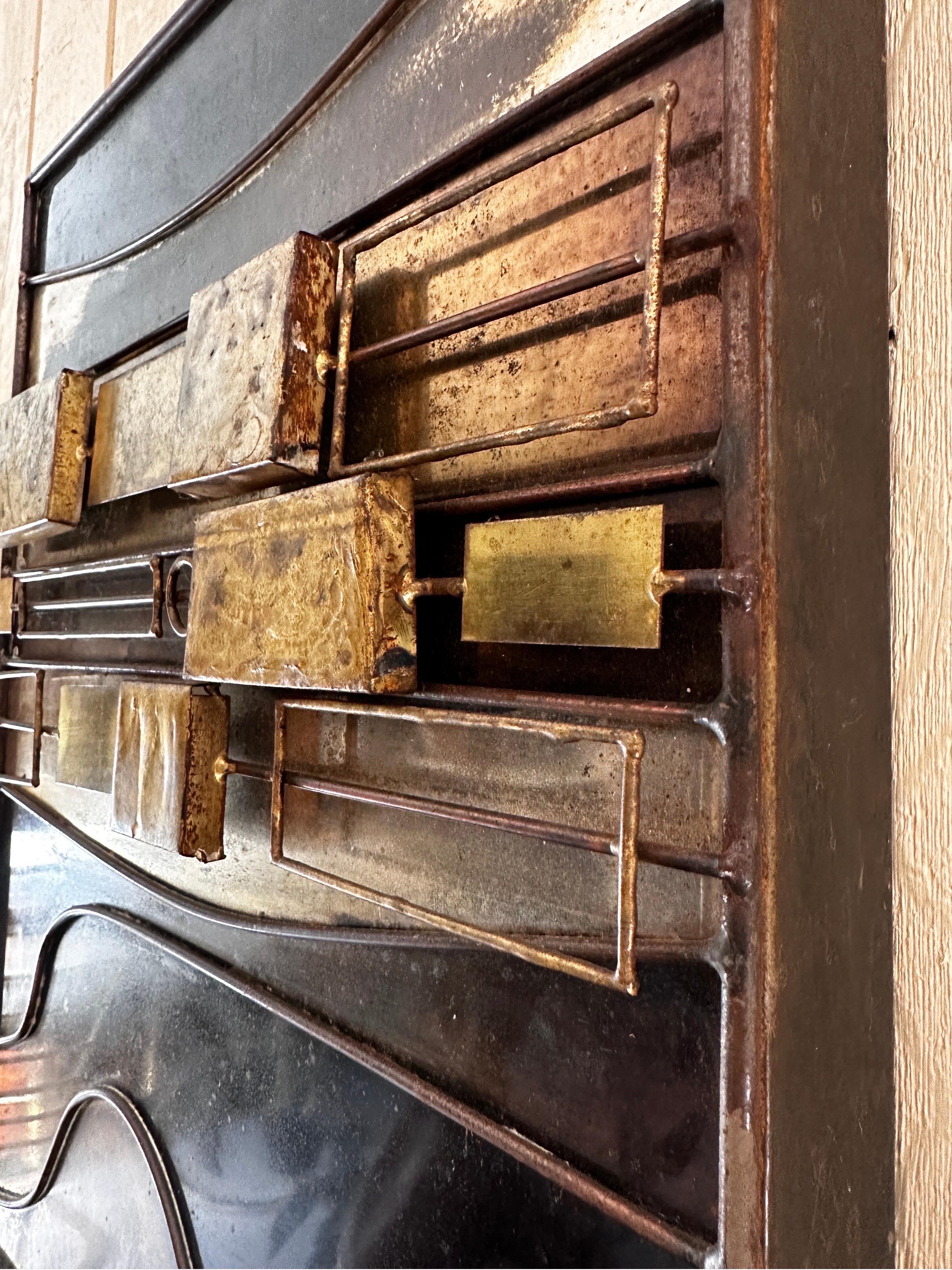 Beautiful blend of subtle color and texture in a masculine brutalist form with presence. Signed. Likely 1970s. This particular example is two panels professionally joined for a great narrow composition. 

Brass, steel, bronze, wonderful patina,