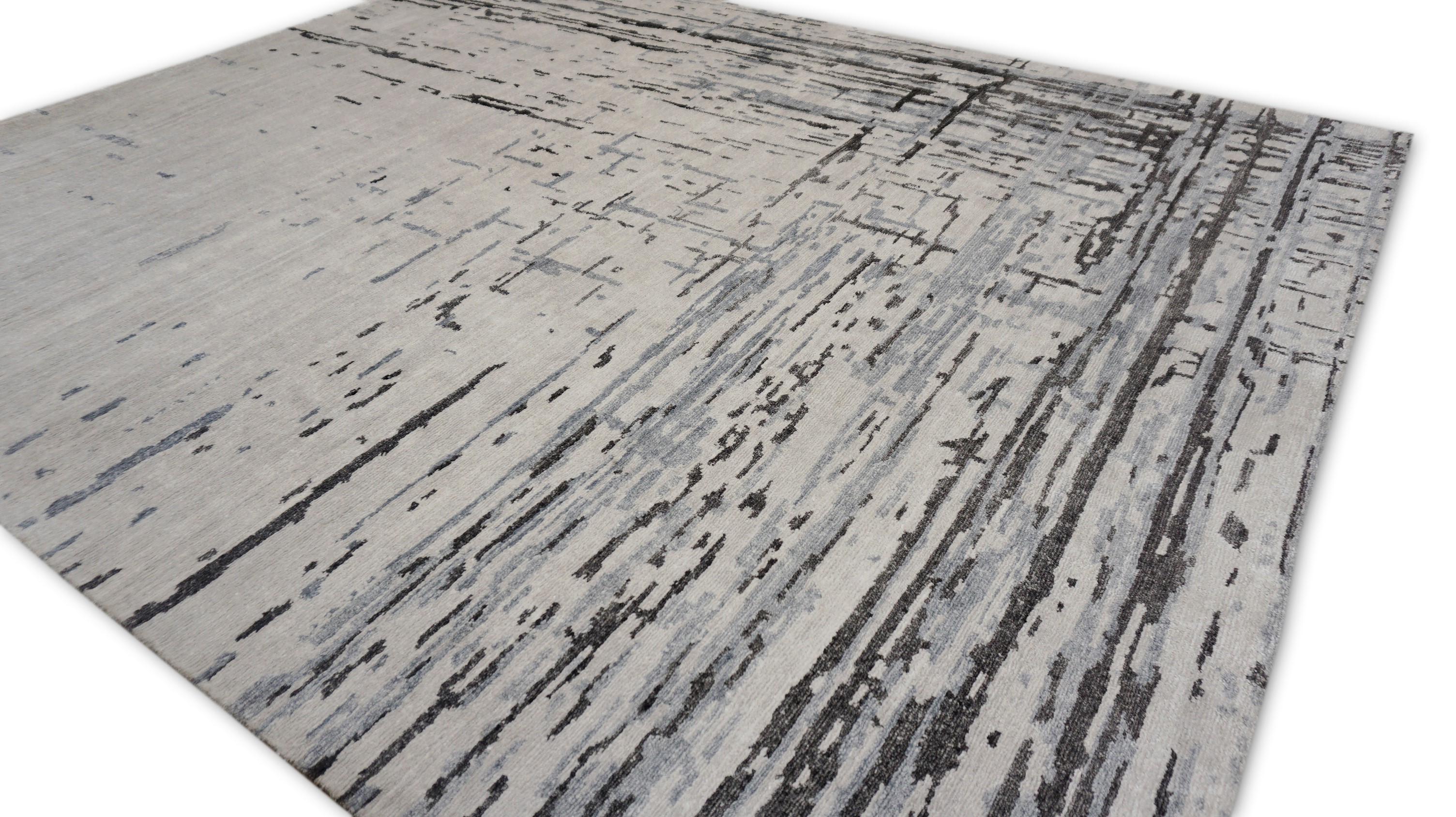 Esta impresionante alfombra de seda de bambú anudada a mano es una clase magistral de arte textil contemporáneo, diseñada para aportar sofisticación y calma a cualquier espacio moderno. Clasificada como alfombra abstracta de transición, combina a la