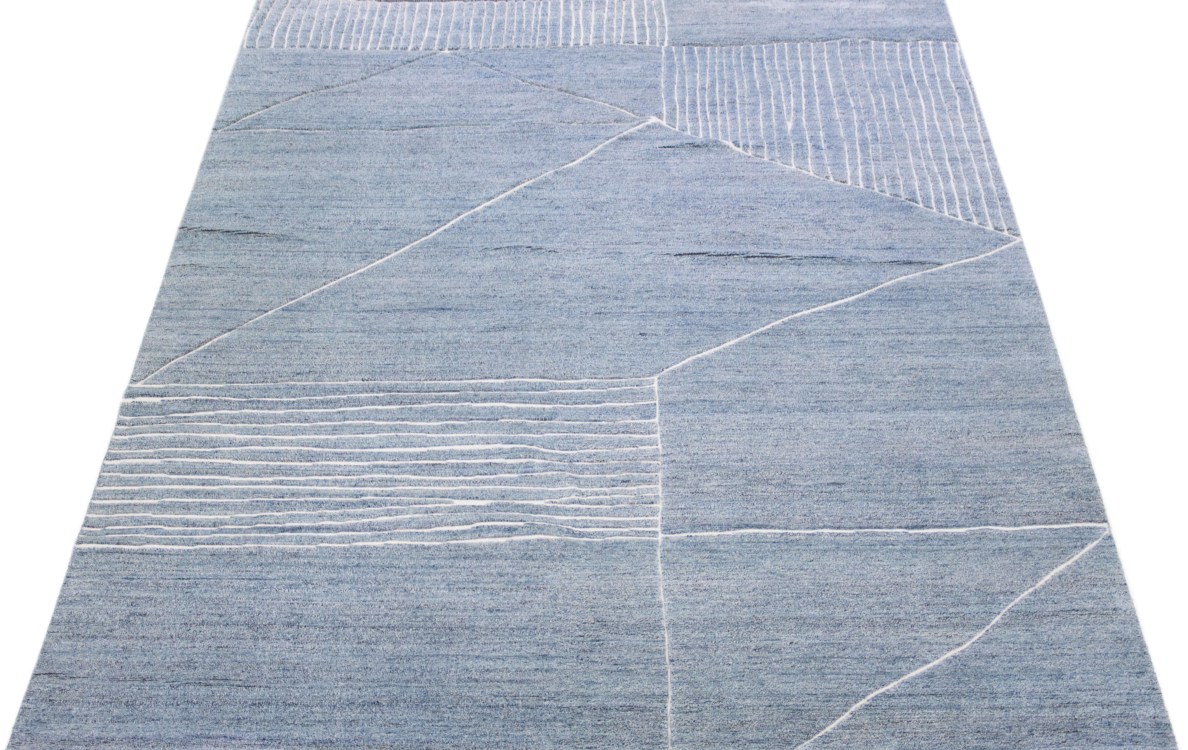 Beautiful modern Moroccan-style hand-knotted wool rug with a light blue color field. This rug is part of our Apadana's Safi Collection and features a geometric design in white.

This rug measures: 10' x 13'10