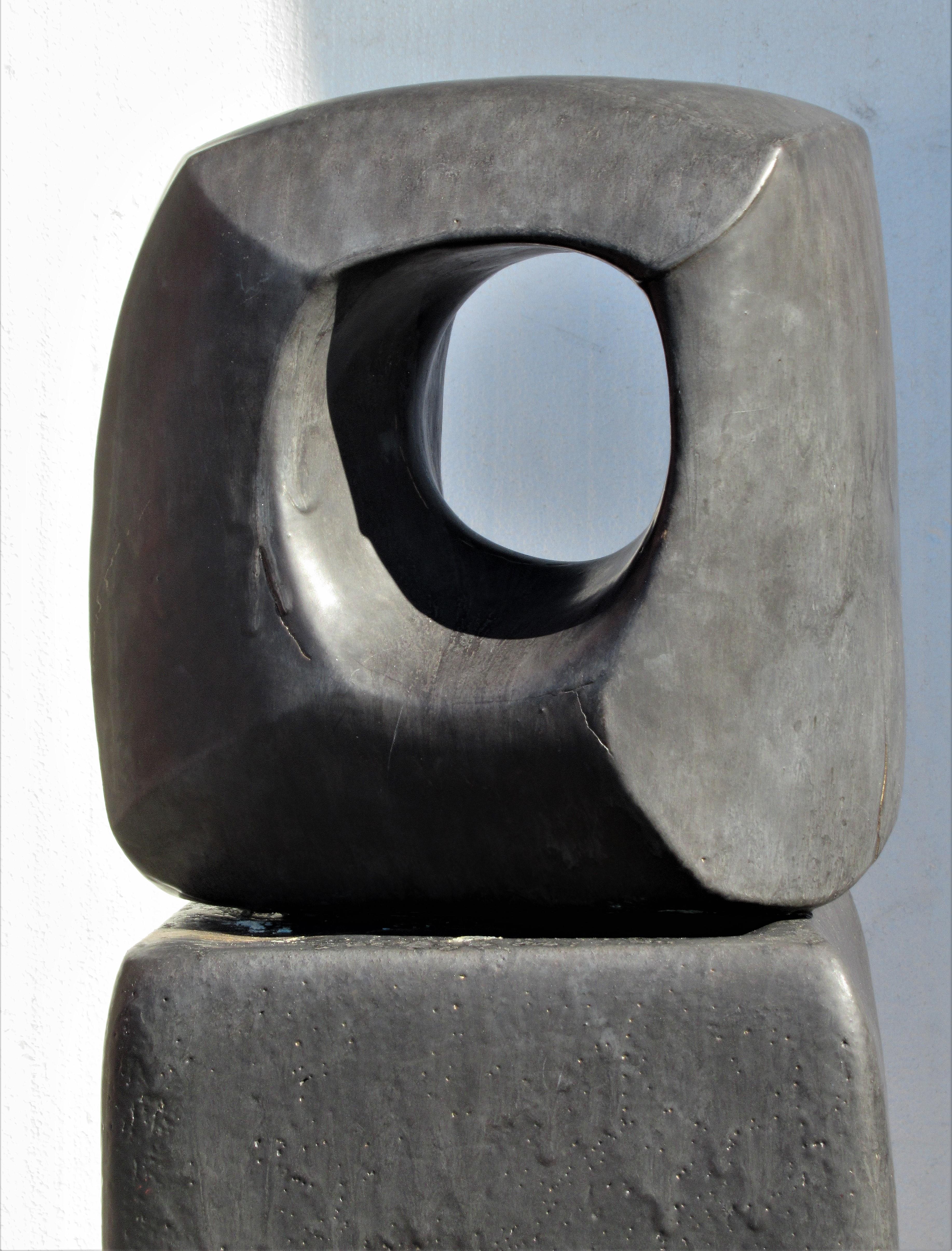 Abstract modernist slate black satin glazed hand built studio ceramic sculpture with accompanying hand built pedestal. In the manner of Barbara Hepworth, dating from the latter part of the 20th century. Illegibly signed on underside of sculpture.