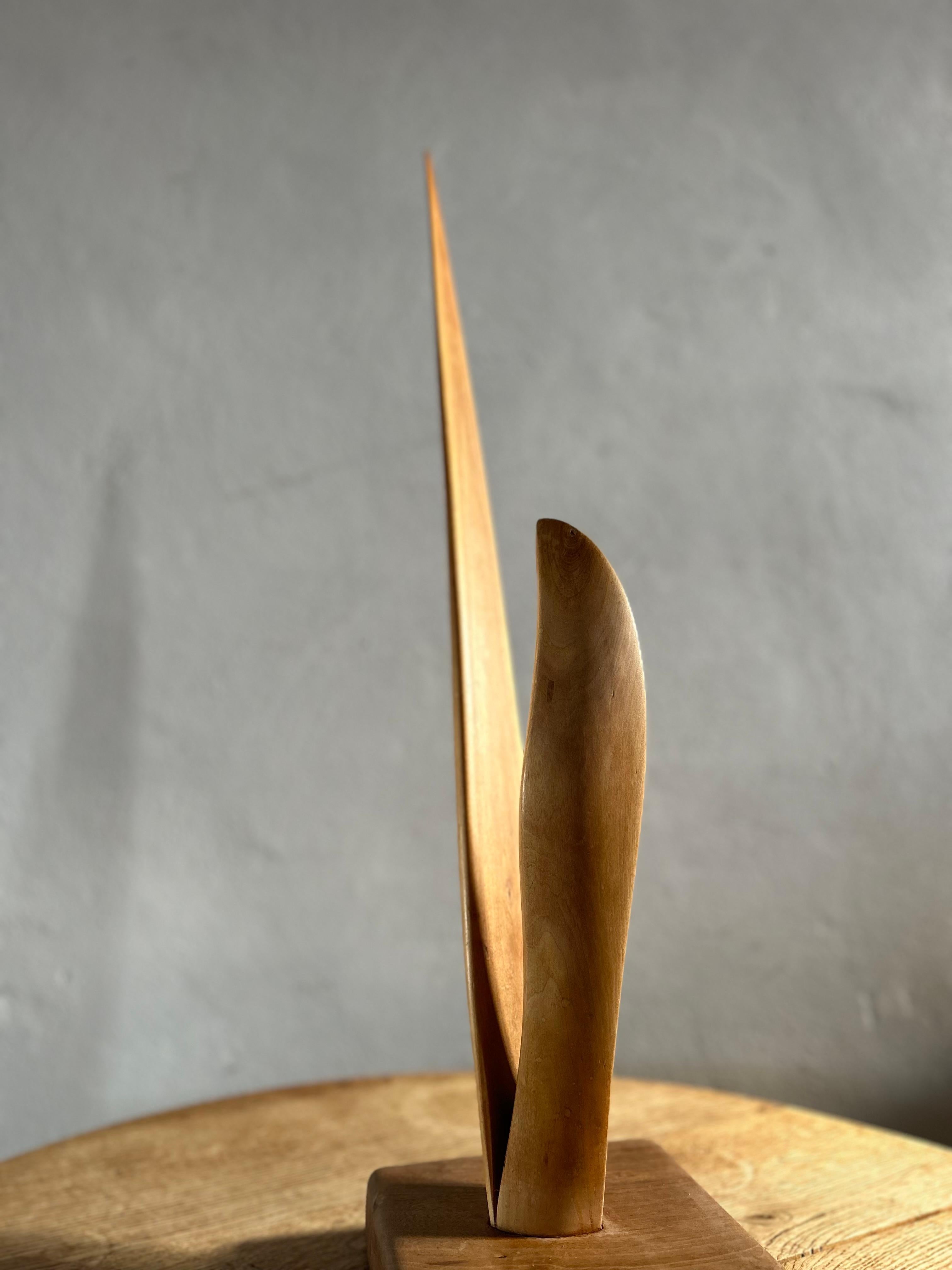 This striking wooden sculpture, crafted in Sweden in 1977, embodies the essence of abstract modernism. With its sleek lines and dynamic form, this piece captivates viewers with its timeless elegance and artistic expression. Hand-carved from