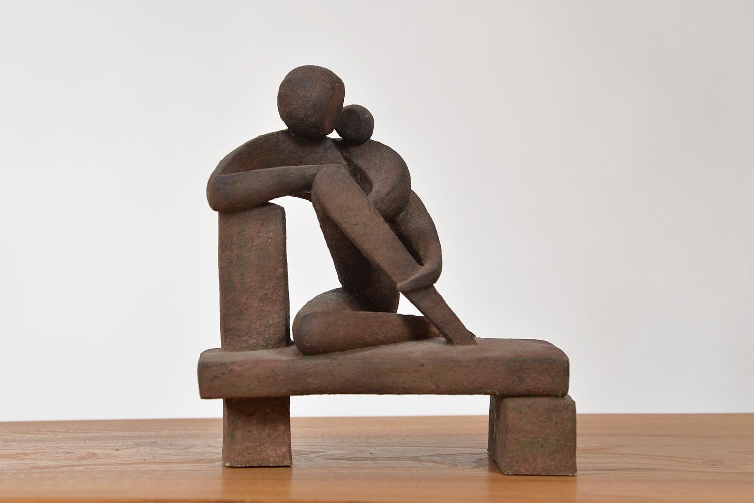 A very beautiful 1960s abstract pottery sculpture of a mother and child seated on a plinth. There is a wonderful contrast between the soft sweeping curves of the figures that intertwine with one another, and the hard angular seat they are sat upon.