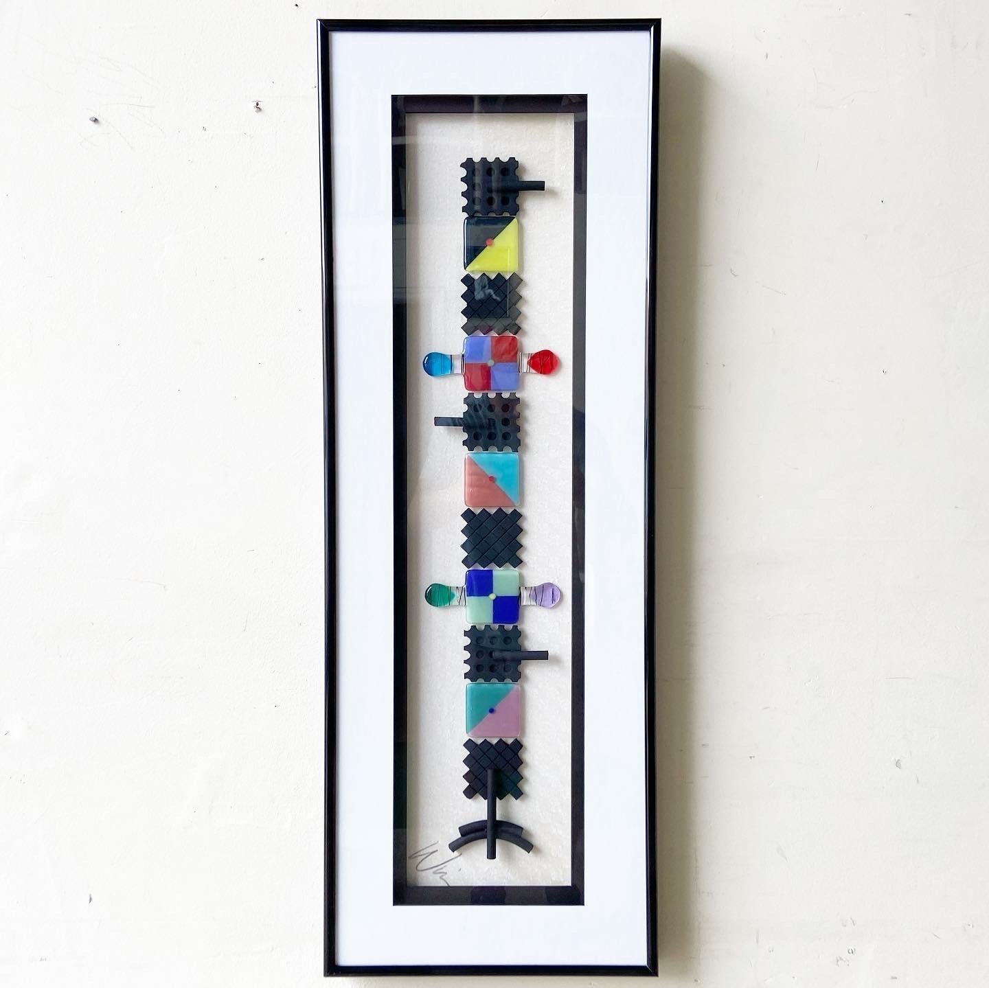 Exceptional frames 1980s postmodern artwork. Piece is comprised of sculpted pieces of colorful glass geometrically depicting a pathfinder totem poll.
    