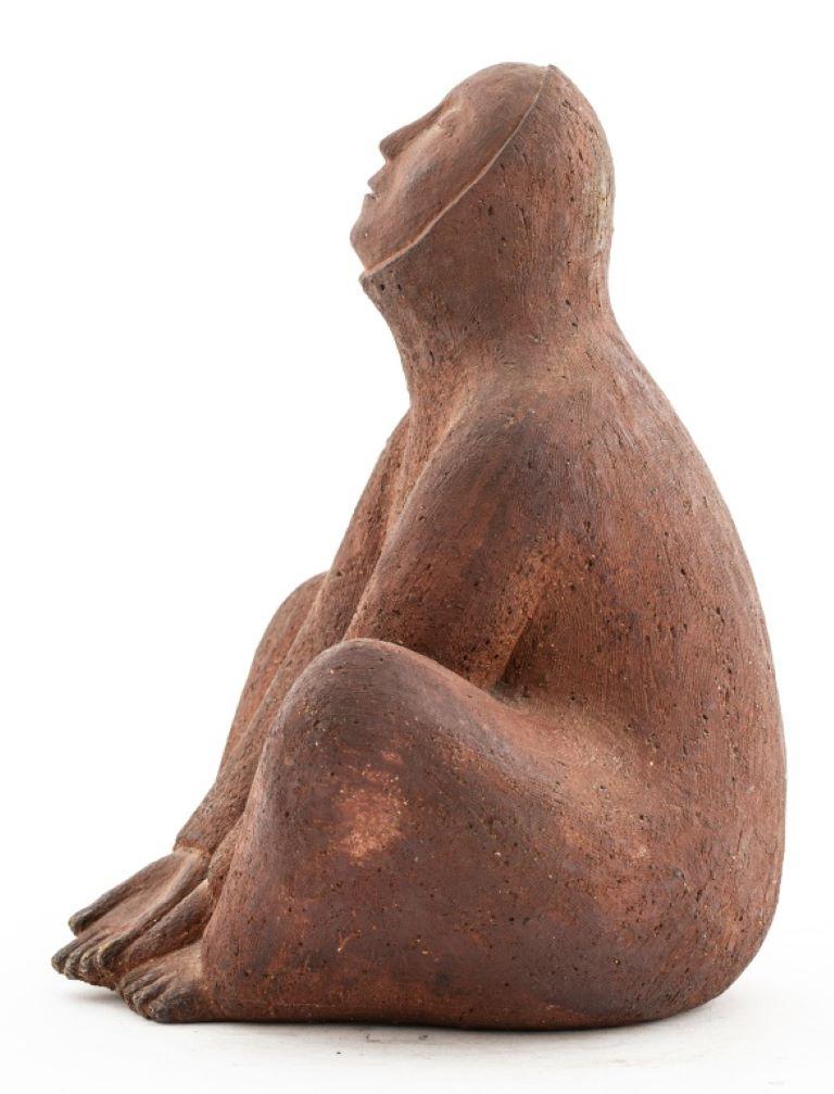 Abstract red clay sculpture of a seated figure with arms outstretched and head held high. Signed 