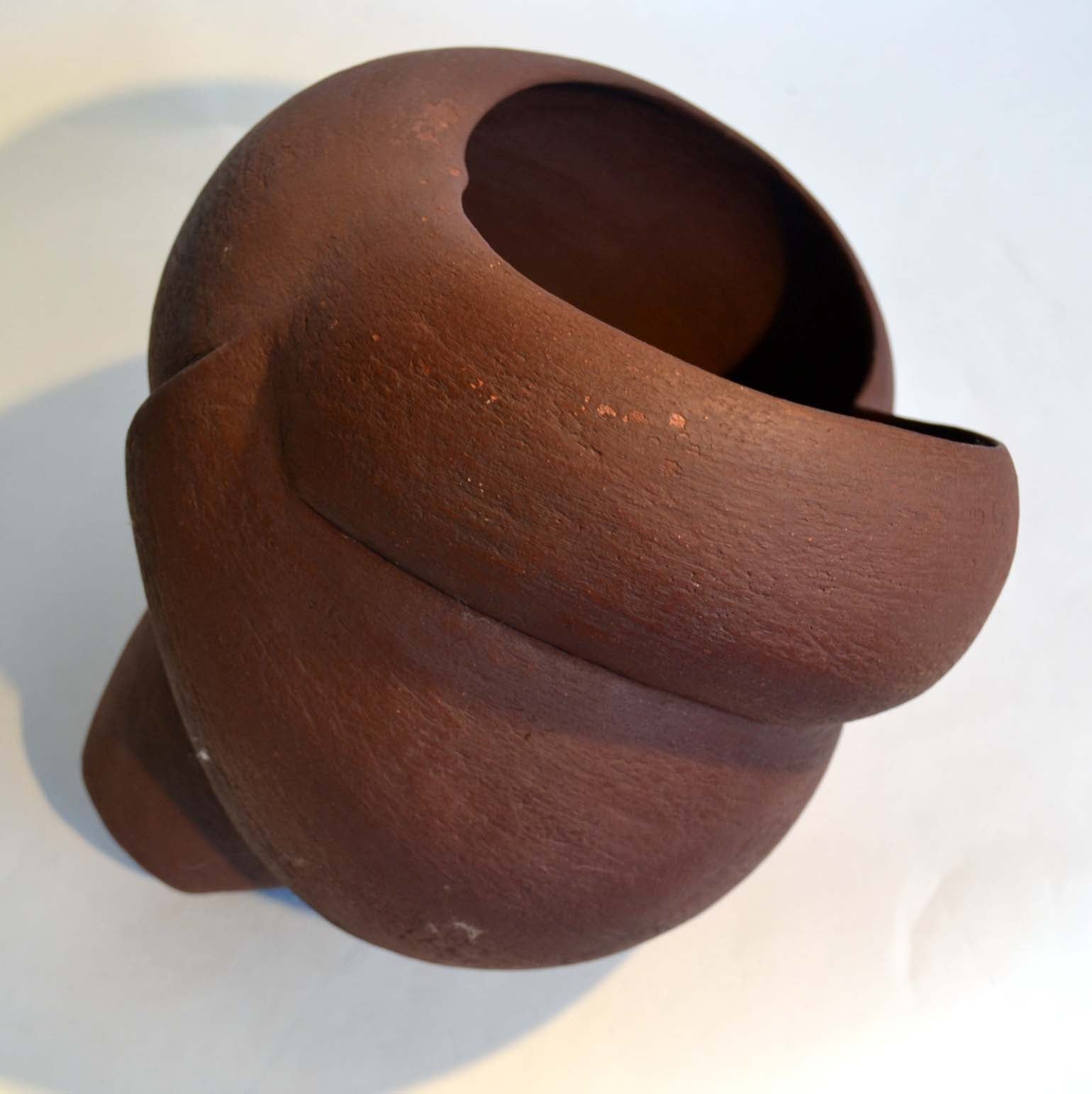 Escultura abstracta hecha a mano con forma de gran concha marina, esmaltada en marrón óxido. Su forma orgánica se ve acentuada por la manera en que se inclina lateralmente descansando en su posición natural, por Germaine Jones 1994.
 
Germaine