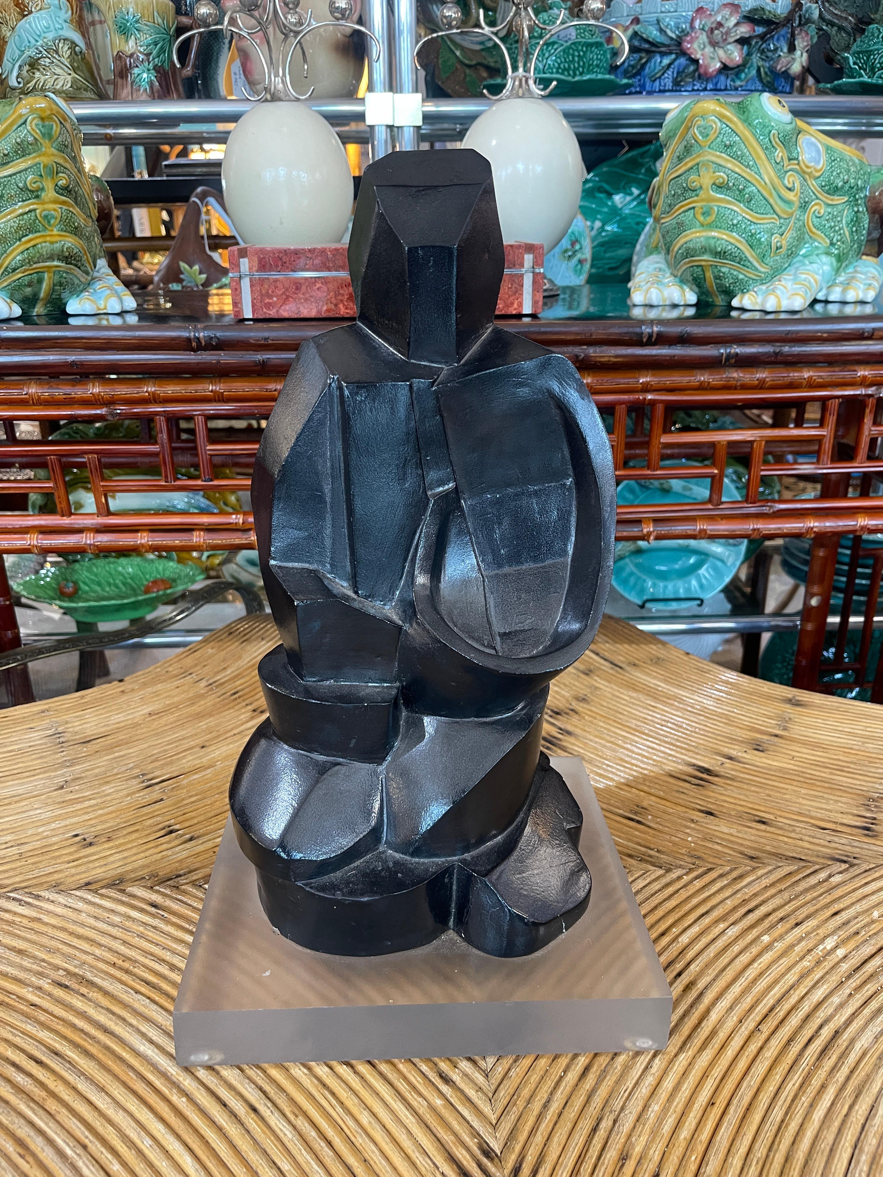 Si tratta di una scultura astratta molto intrigante, in stile  Stile brutalista, di una statuetta su base di lucite.
A quanto mi risulta, è stata realizzata con una pietra molto pesante e smaltata in colore nero.
La scultura si erge su una base