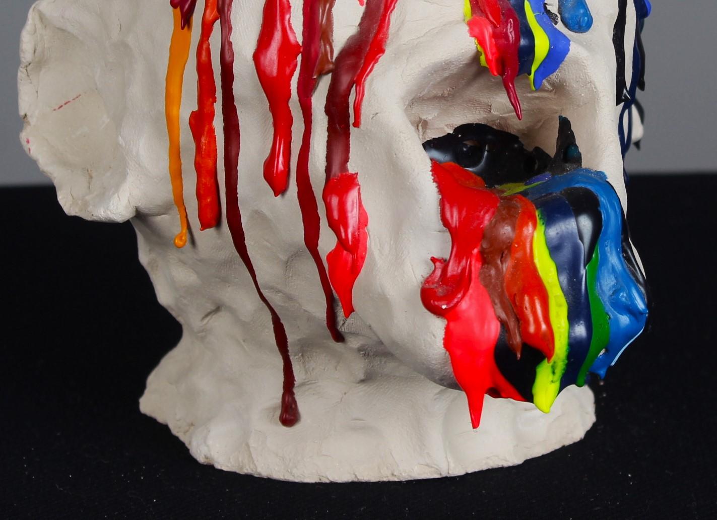 Handgefertigte Skulptur eines Kopfes. 
Aus den Augen, der Nase und dem Mund strömt bunte Acrylfarbe.
Unbekannter Künstler, 21. Jahrhundert.