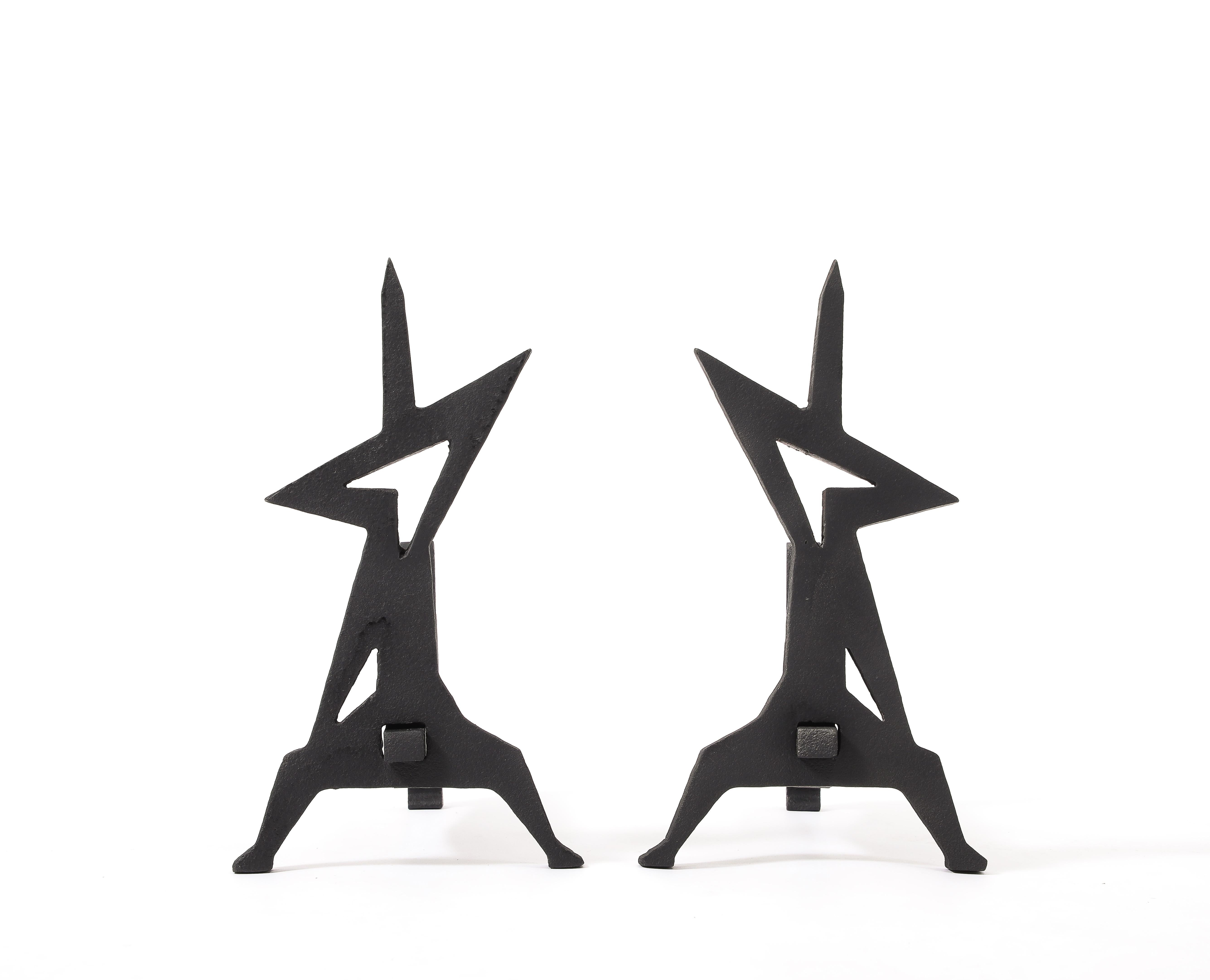 A pair of andirons torch cut out of solid thick steel, the shape evokes the outlines of a man.