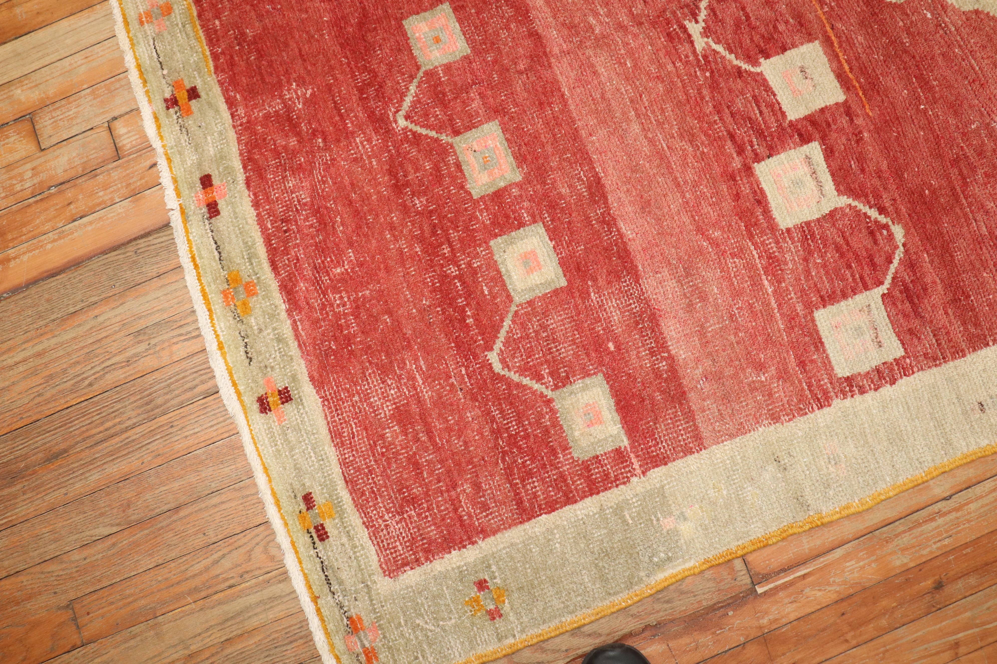 An abstract midcentury Turkish Anatolian rug with a brick red field with accents in green and pink.

Size: 4'6” x 7'2”

Turkish carpets and rugs, whether hand knotted or flat-woven, are among the most well-known and established handcrafted art