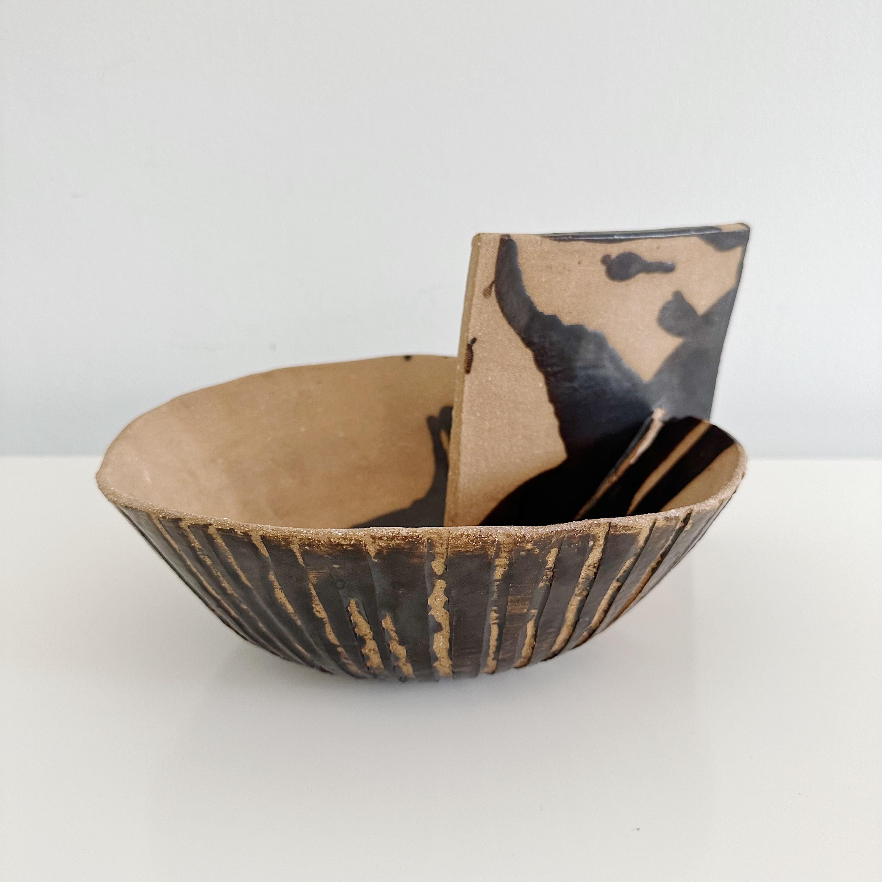 Unique vintage handmade studio pottery sculptural bowl with a distinctive two tone abstract bird-like design, featuring an inserted angular pottery piece on the side. The side piece shows signs of splitting from the firing process. Dark brown and