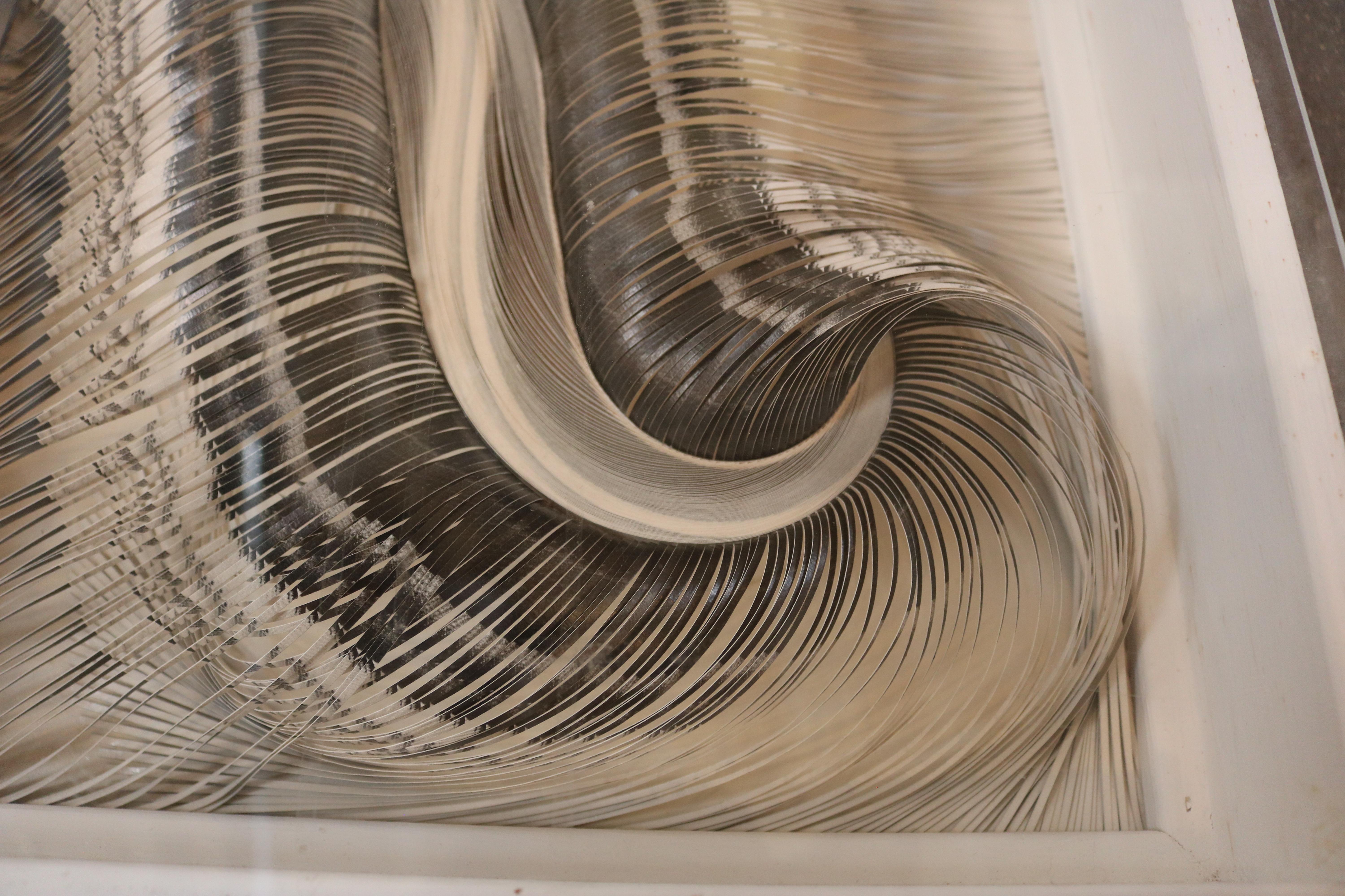 This noteworthy abstract wall sculpture by Eve Tartar almost resembles an expanded Slinky. It has the words 