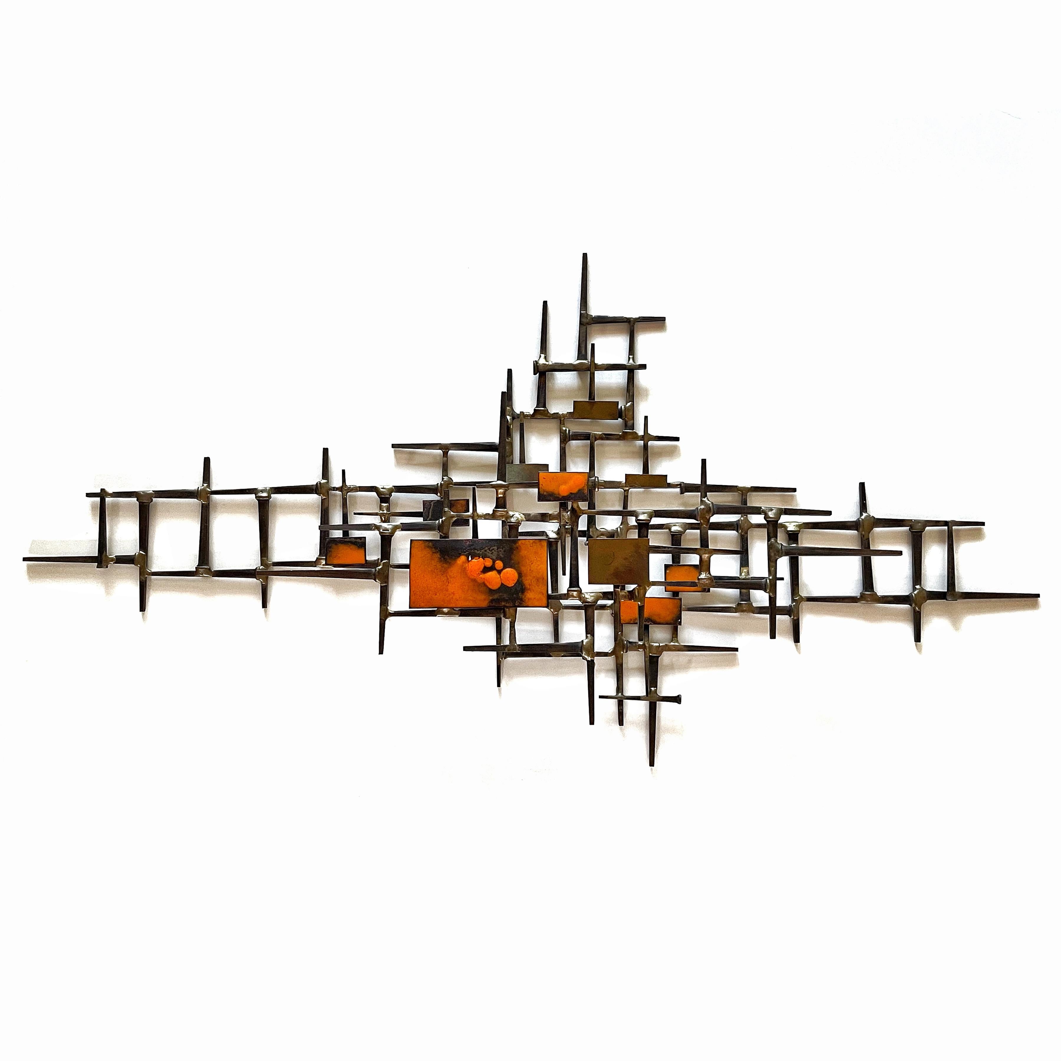 This terrific abstract sculpture has a wonderful linear composition created with iron brick nails welded with bronze and a patchwork of rectangles in enameled in vivid orange.

The piece looks great hung in any orientation.

18.5