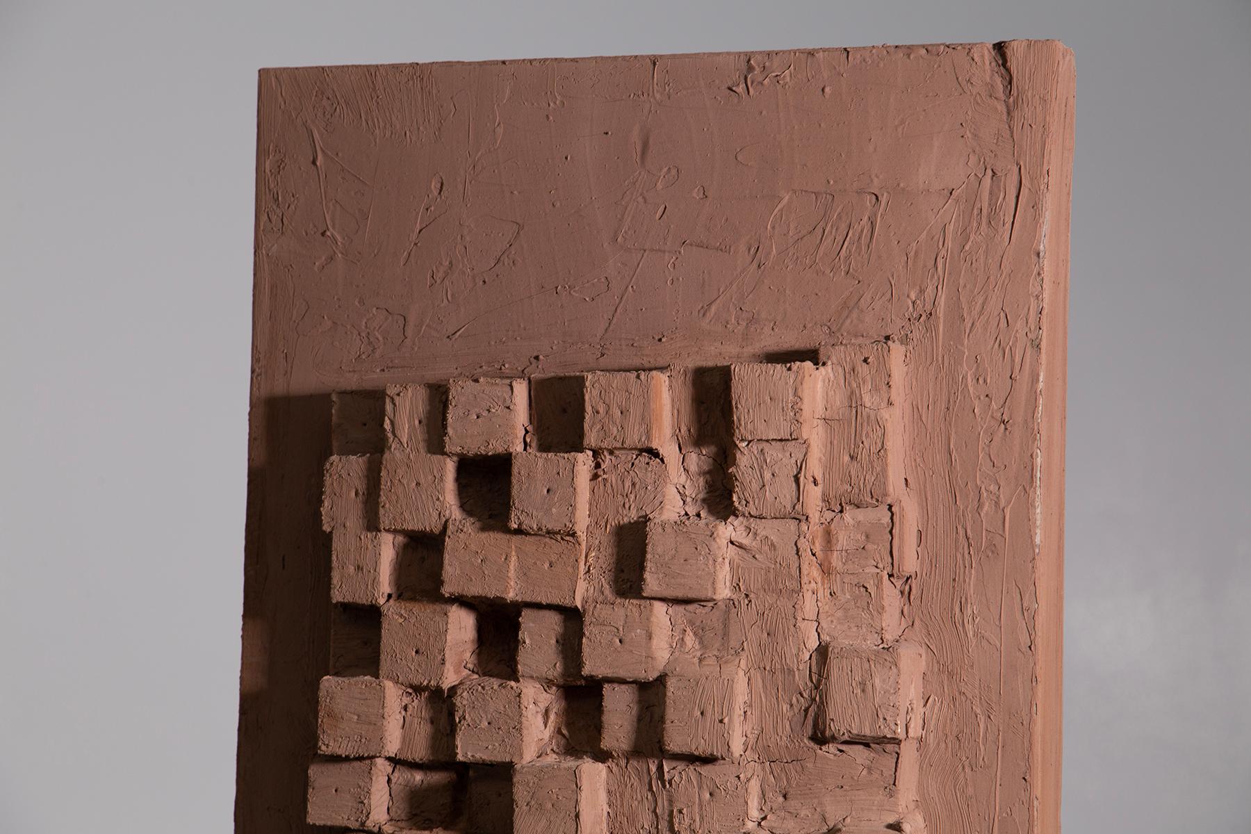This sculpture by Aldo Guarnieri, created in the 1990s, speaks with the strength of the material and the delicacy of form. Crafted from wood, its surface resembles a mosaic of interwoven and overlapping cubes, creating a play of light and shadow
