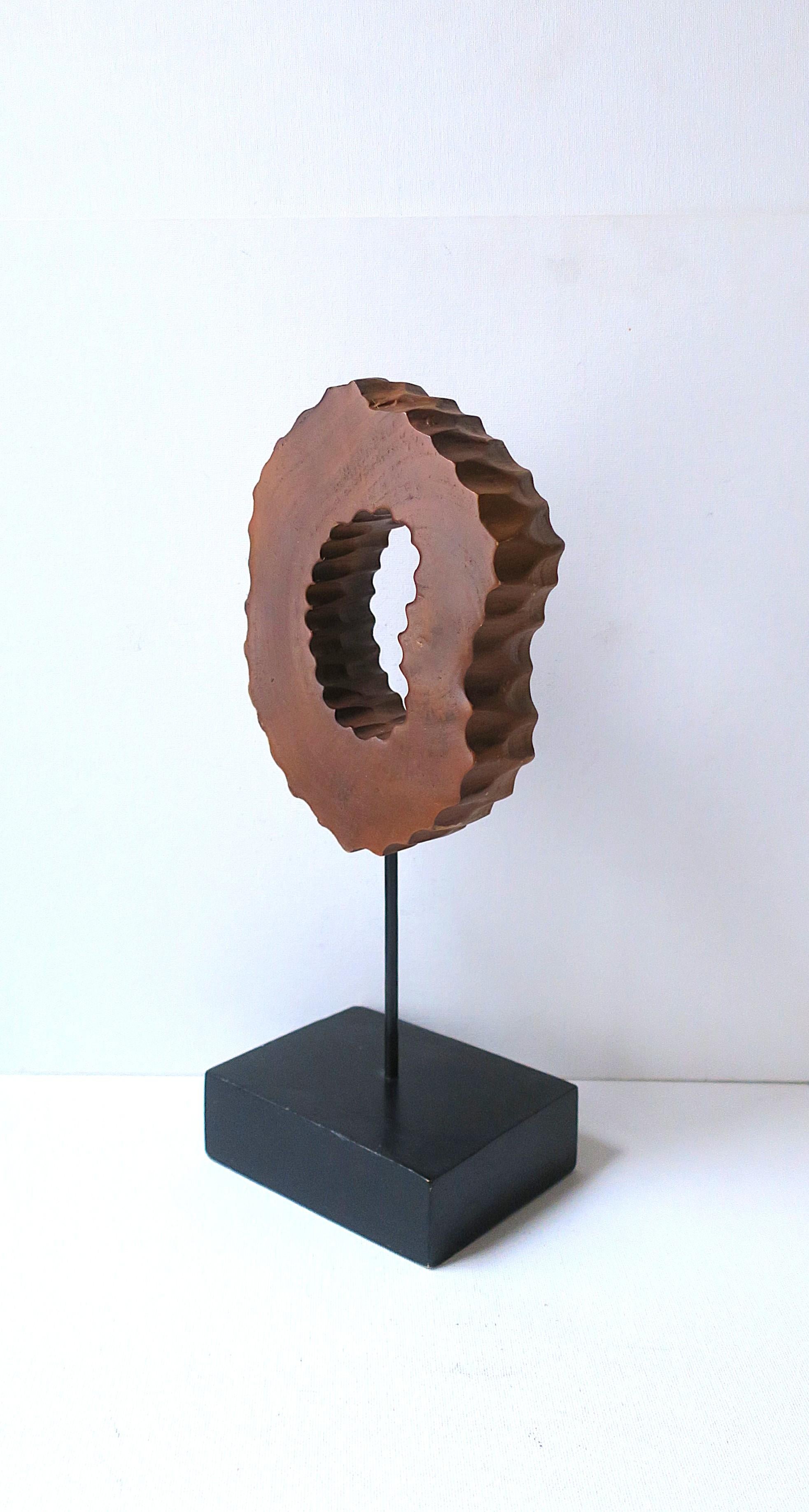 Una scultura astratta in legno marrone/marrone chiaro con taglio centrale su una base in legno nero. Un grande pezzo per uno scaffale, un tavolo/credenza, ecc. Dimensioni: 3,88