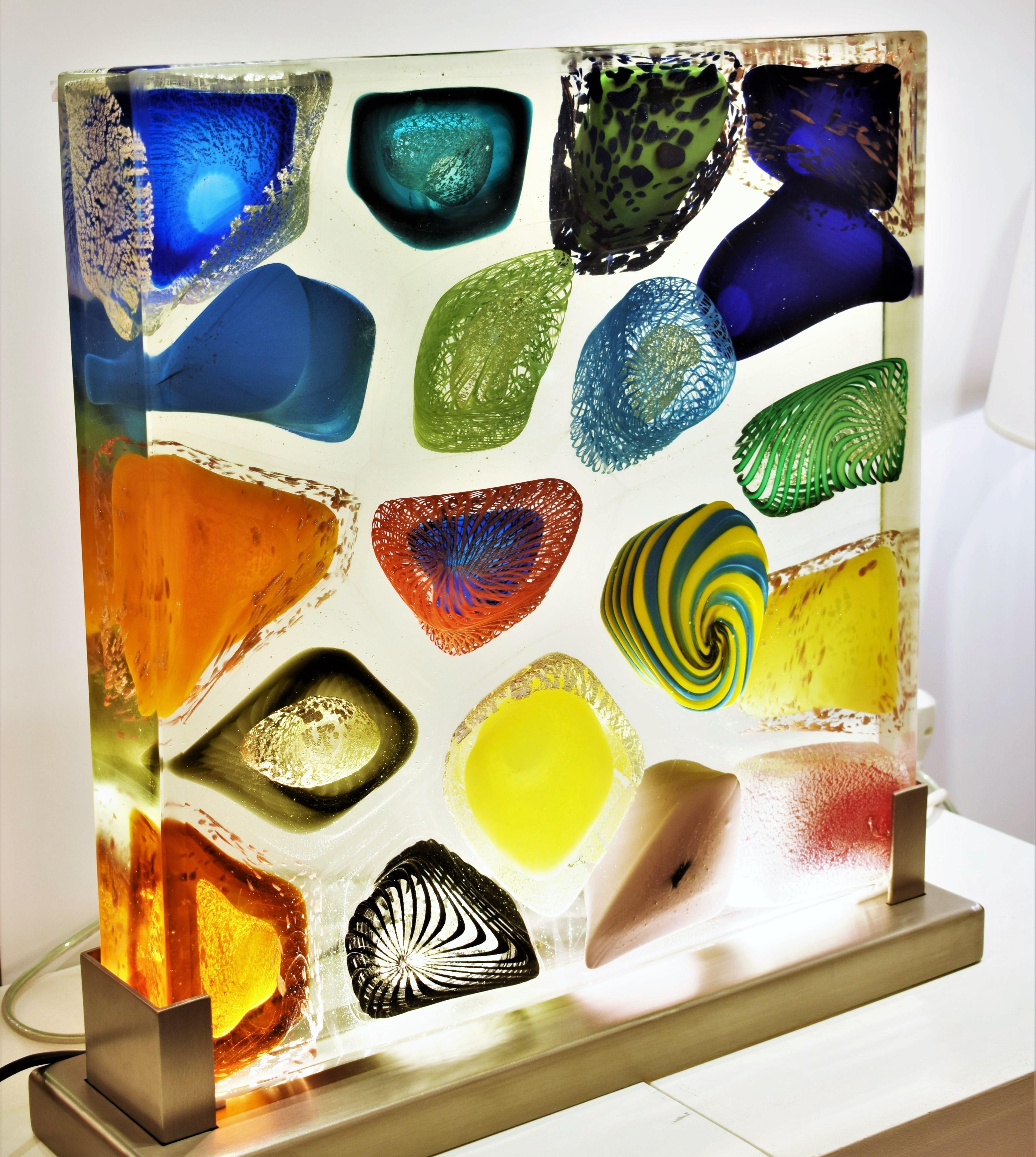 Luminous monolith in murano artistic glass. The murano artistic glass sculpture is a creative and natural expression of the artist Eros Raffael, made with transparent and pastel glass canes, silver, pure gold, gold aventurine, zanfirico, filigree