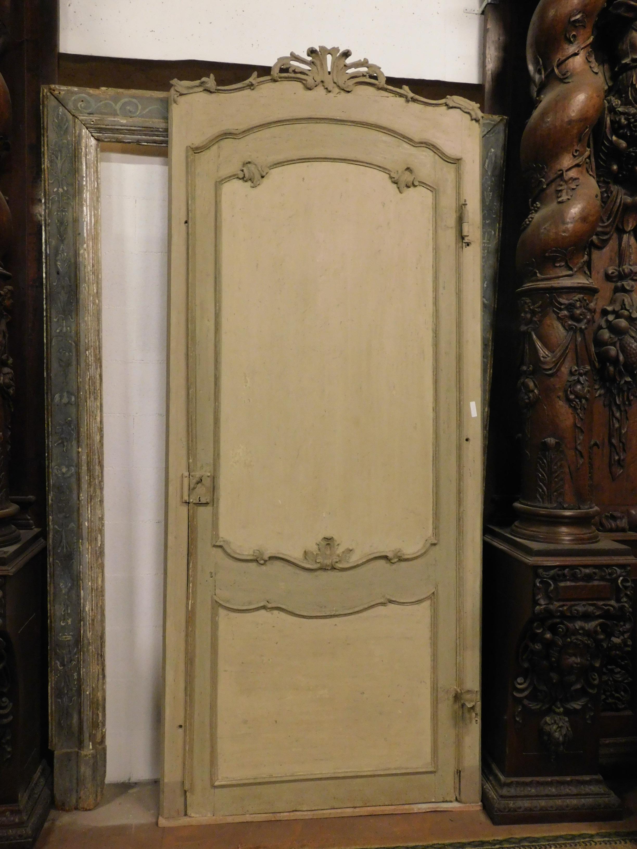 Ancient arched door in the upper part, lacquered by hand with warm gray - beige colors, with carved shells and original gooseneck iron, from a noble house of the 18th century in Italy.
The frame with frieze measures maximum height 271 cm x 117