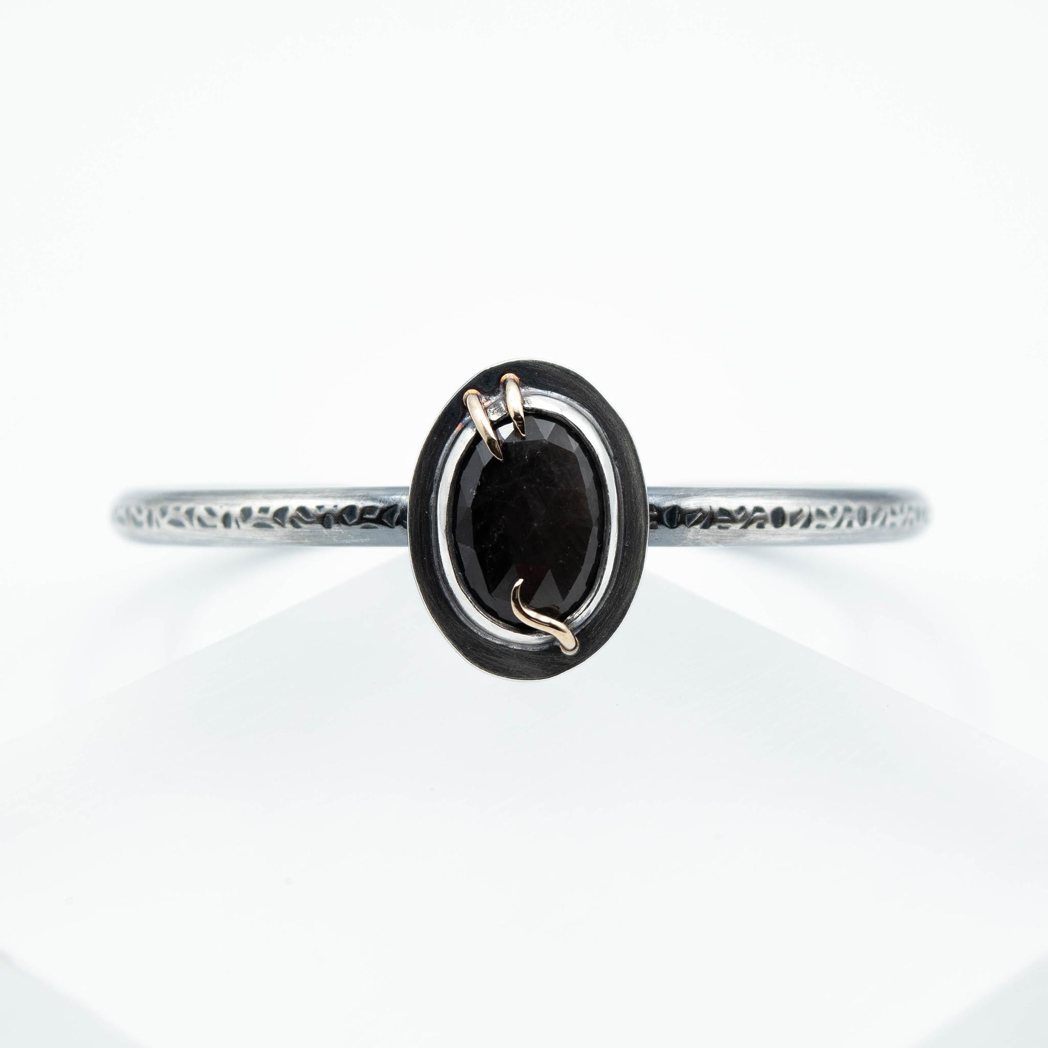 The visual elements of the Black Sapphire Abyss Cuff Bracelet was inspired by nature, elemental forms, and the inward journey. Sustainably handcrafted with recycled sterling silver and fine silver, and is adorned with a mesmerizing rosecut black