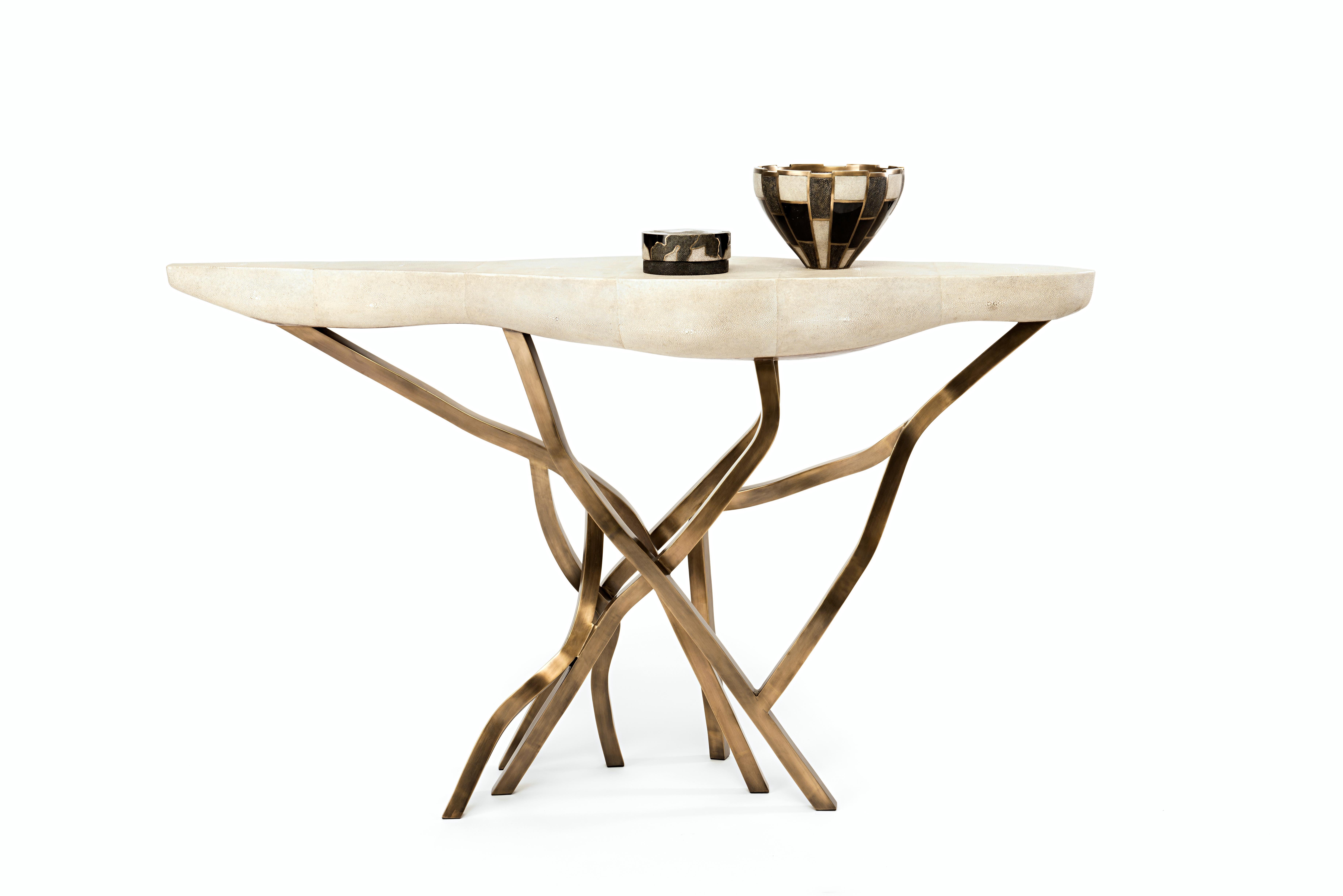 La table console Acacia constitue une pièce d'apparat spectaculaire dans n'importe quel espace. Le plateau de forme amorphe est en crème et les pieds de forme organique sont en laiton bronze-patine. Disponible également en noir, voir les images à la