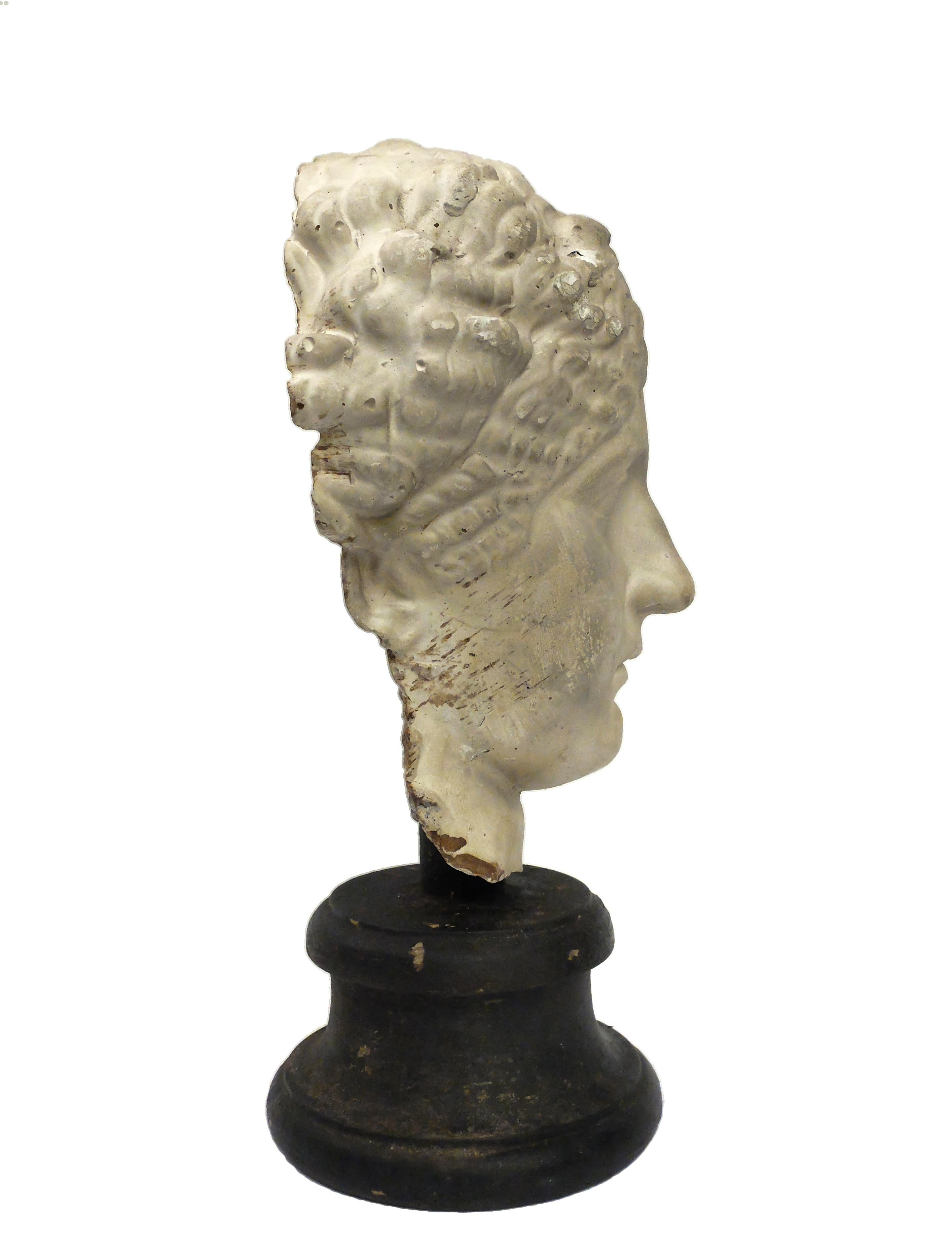 Over the wooden black painted base is set the superb cast of a roman women’s head. The cast for drawing teaching in Academy, Italy, circa 1890.

 