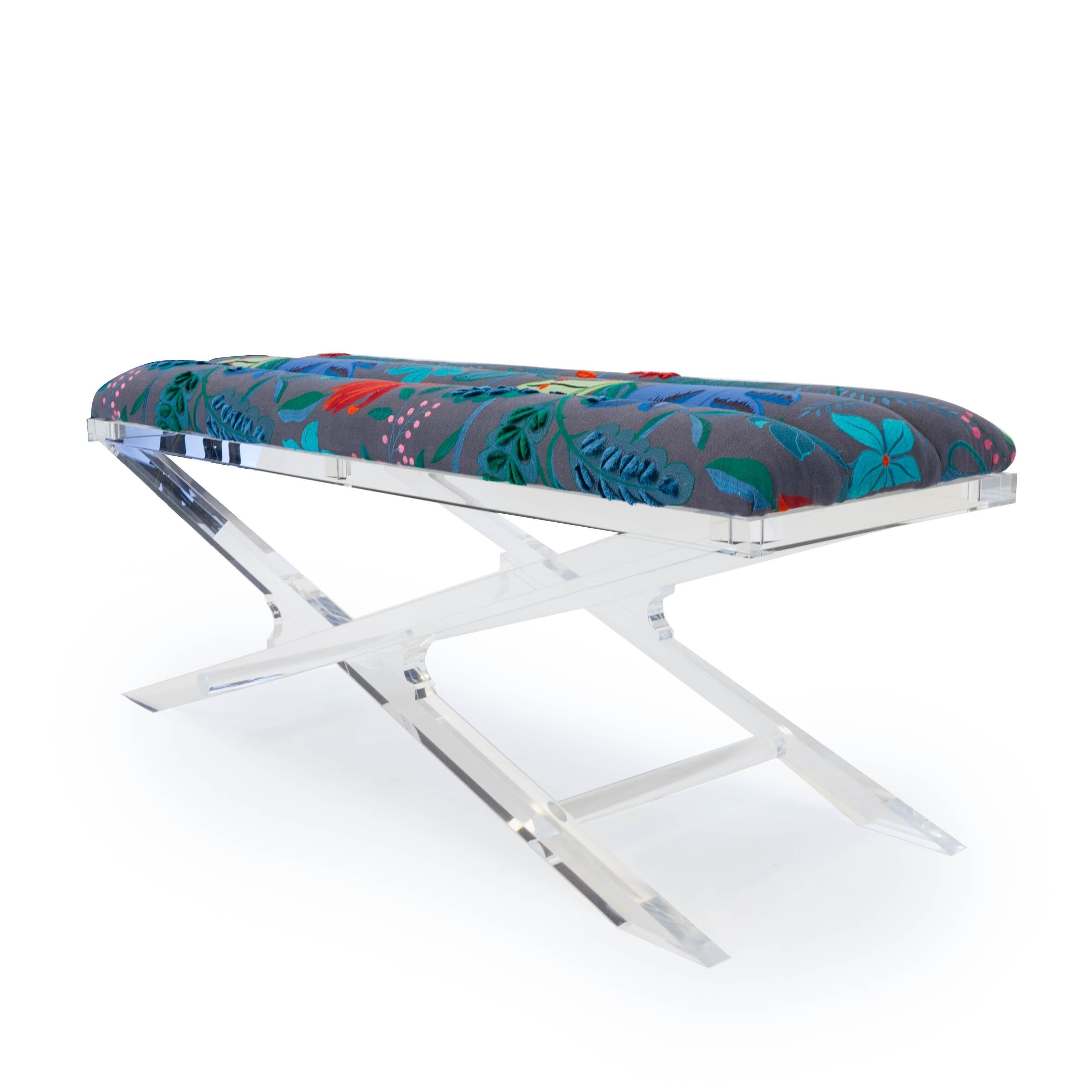 This modern bench features a clear Lucite base and an upholstered channeled cushion. The fabric is a colorful embroidered floral pattern from Jim Thompson fabrics. This piece can be sold as is our custom made with the customer’s choice of fabric.