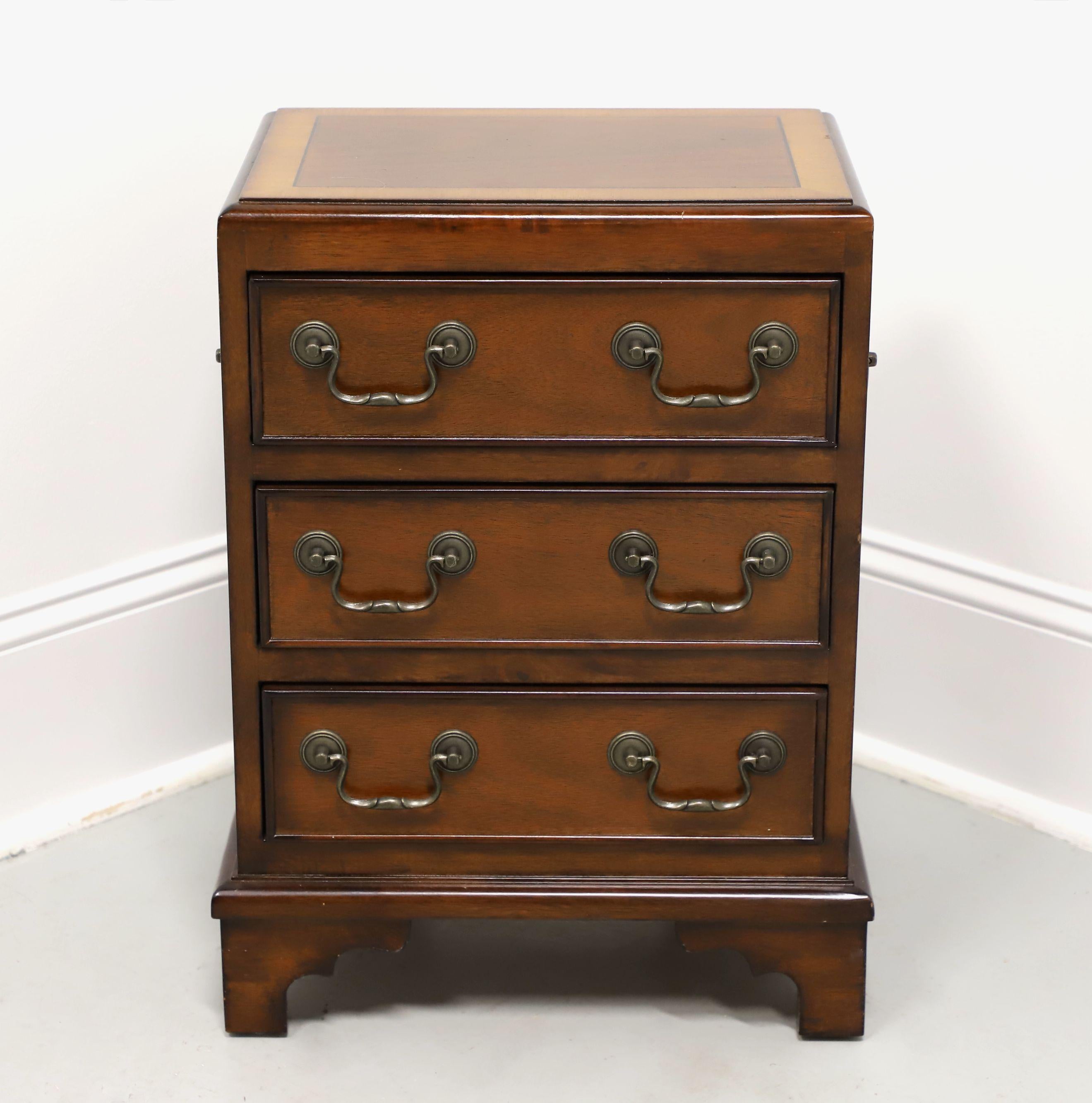 A Chippendale style diminutive three-drawer chairiside chest by Accents Beyond. Mahogany with brass hardware, banded top with bevel edge, finished on all sides, brass side handles, and bracket feet. Features three small drawers. Made in the USA, in