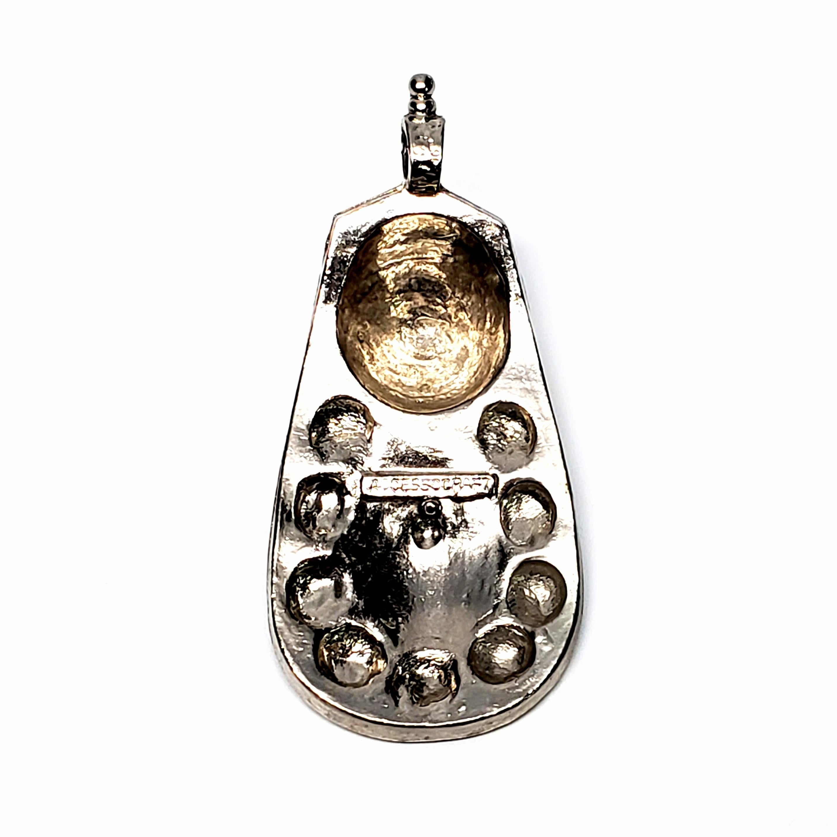 Vintage silver tone pendant by Accessocraft.

Accessocraft was founded in 1930 in NYC and was known for their innovative style and quality.

Measures approx 3