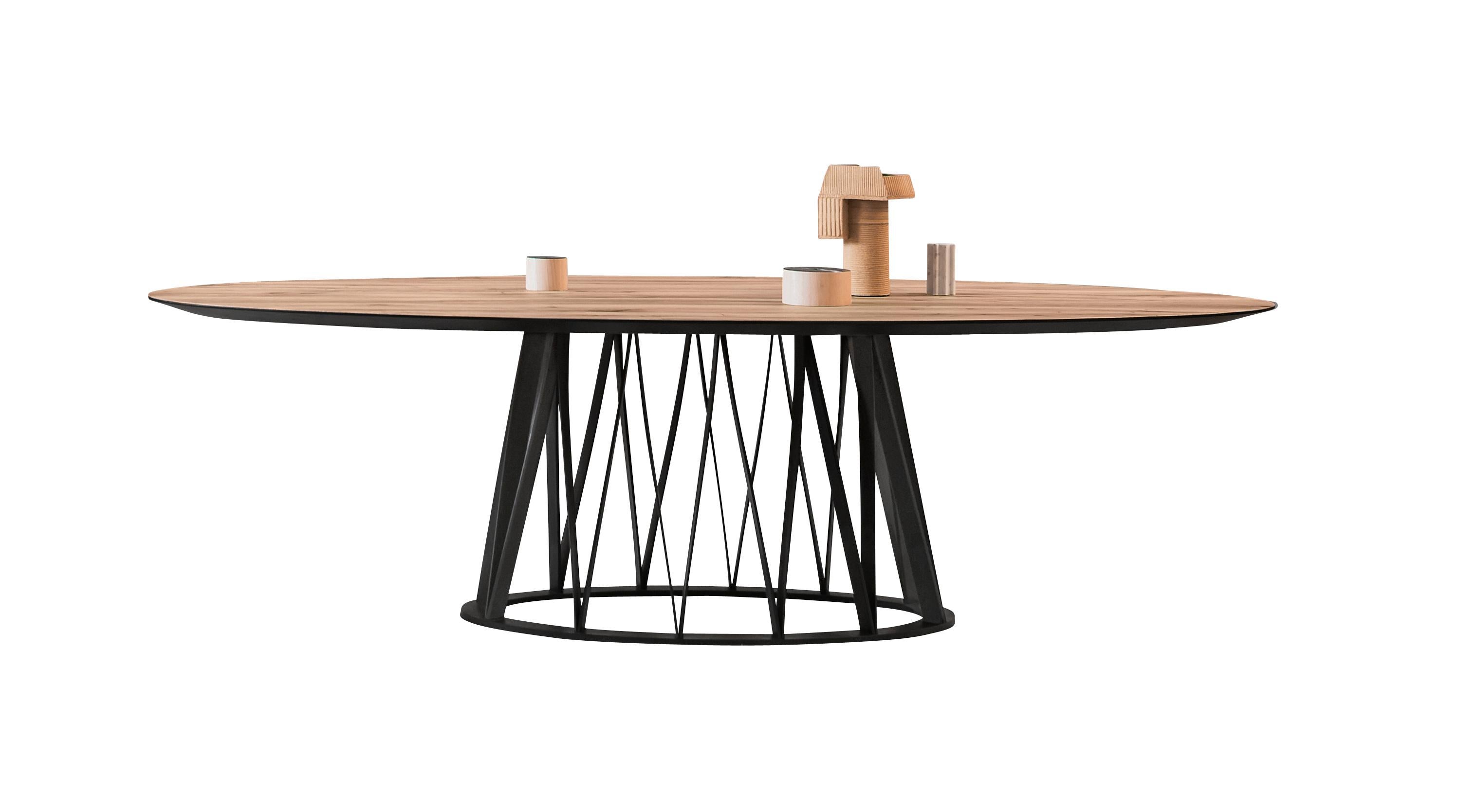 La table Acco est disponible avec un plateau en bois ou en céramique. La base en bois est proposée ici en frêne noir, mais elle est disponible sur commande en chêne naturel ou en noyer Canaletto. Vous voyez ici la grande table de salle à manger Acco