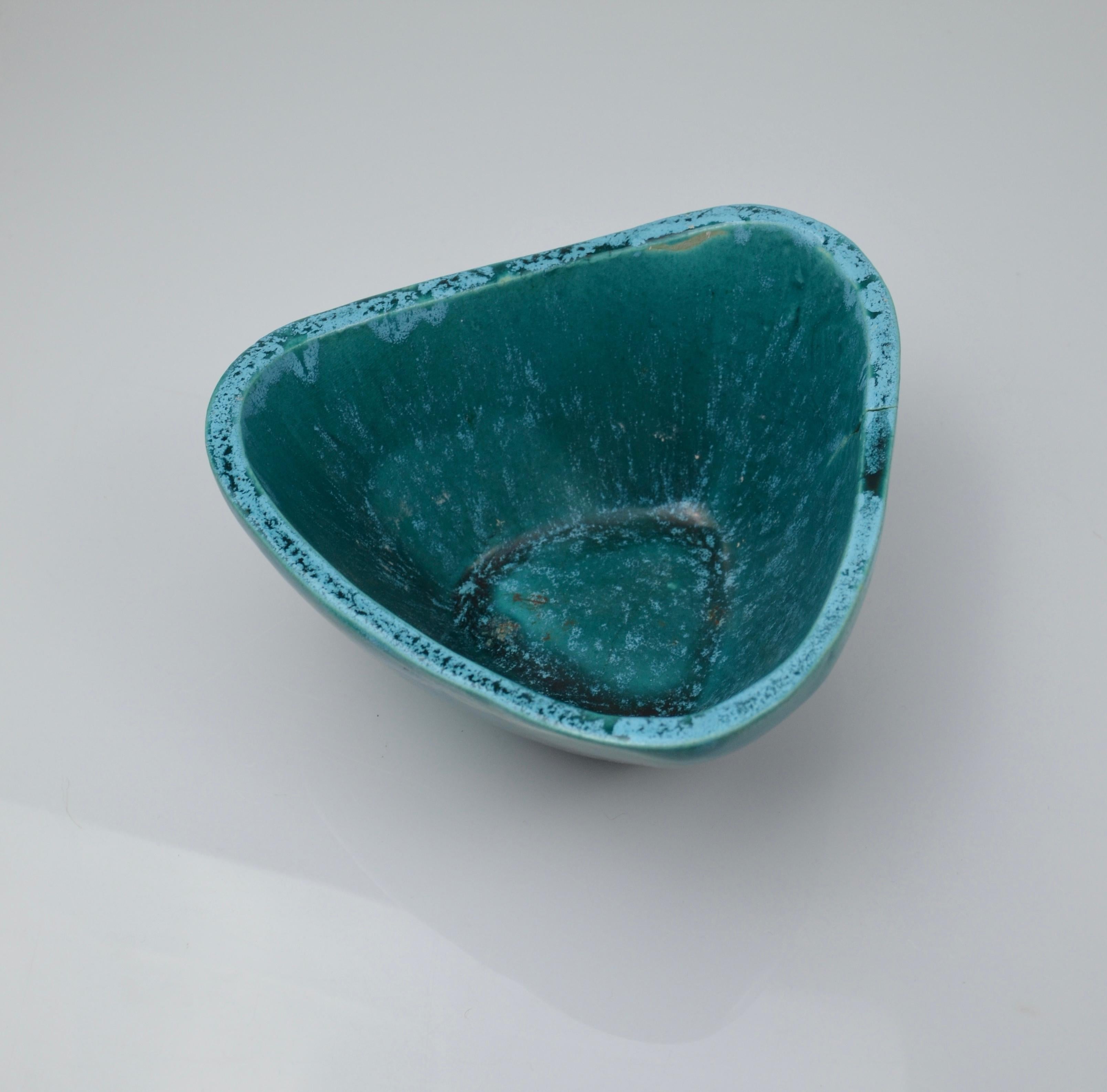 Beautiful ceramic catchall from the Accolay workshops, crafted in the 1950s. Its organic triangular shape and deep turquoise glaze—a hallmark of the Accolay collective—give this piece a strong decorative presence.
The interior features rich textures