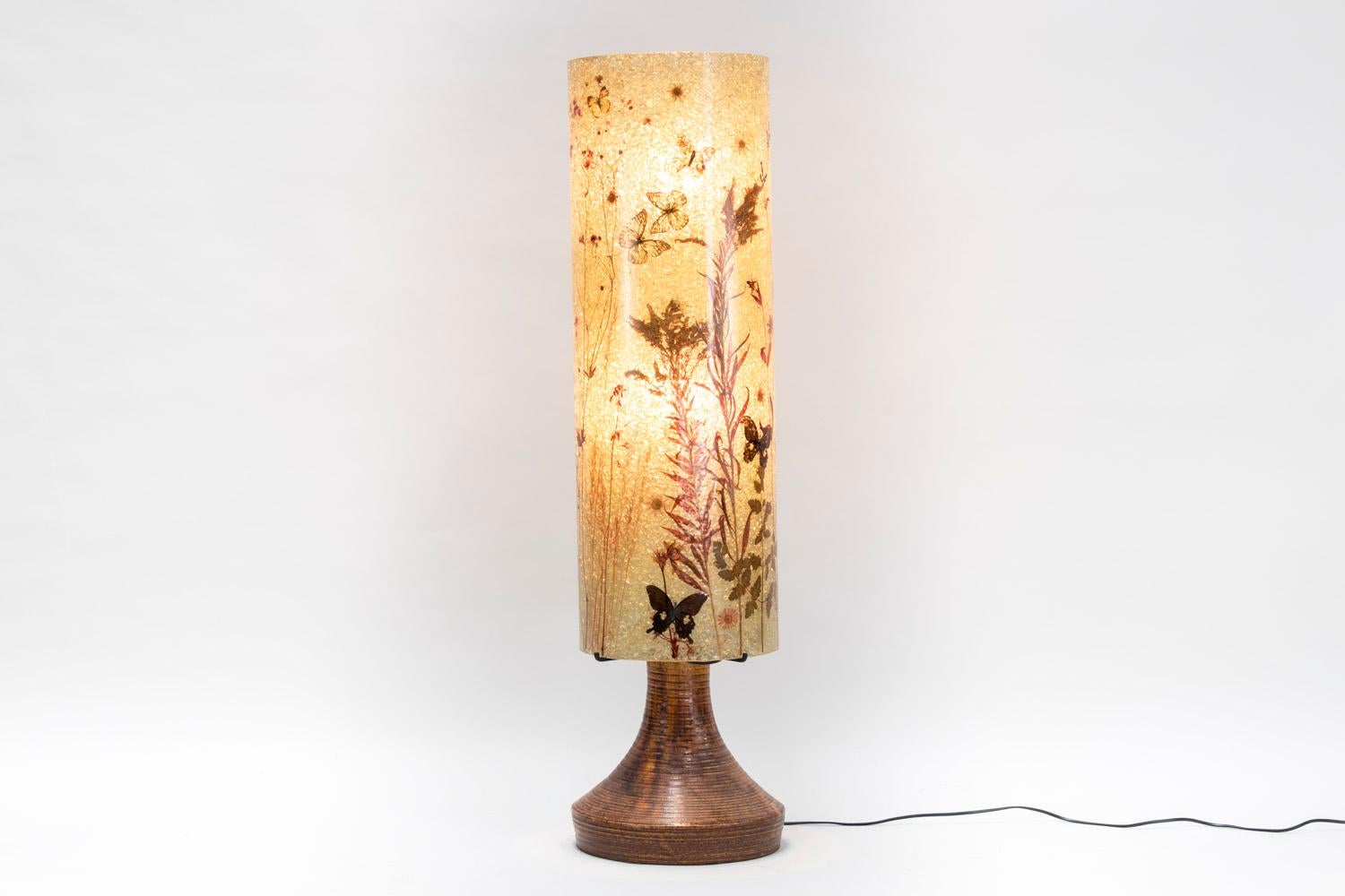 Lamp with brown ceramic round base and beige resin lampshade column shaped decorated with red patterns such as butterflies, foliage and flowers.
Signed Accolay beneath in black letters.
Work from the 1970s.
Functional electrical