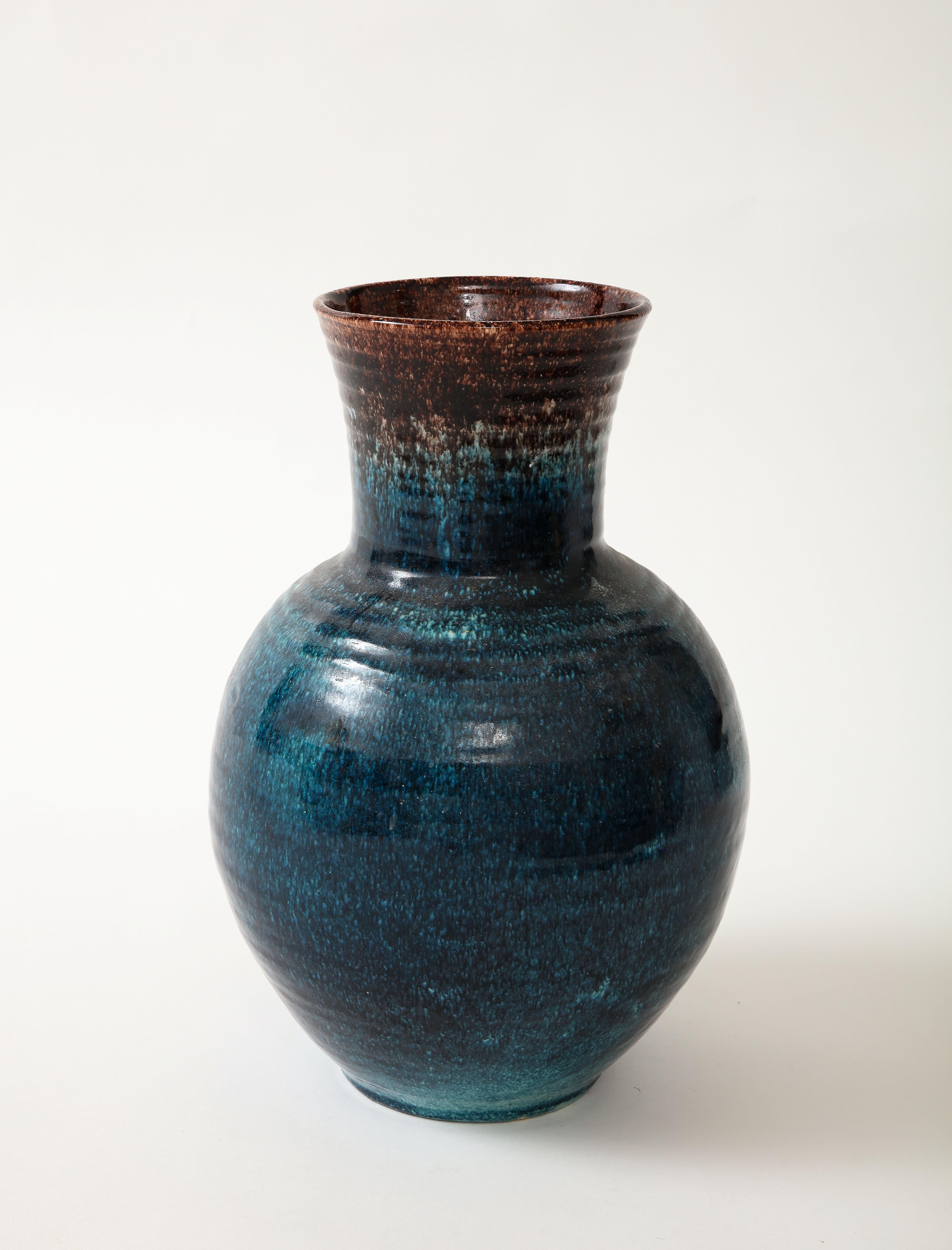 Un vase en céramique dans une belle glaçure bleue et brune produite par Accolay Pottery.  Fondée dans les années 1950 à Accolay,  En France, le Studio Accolay s'est fait connaître en produisant des boutons pour la collection de Christian Dior.  Ce
