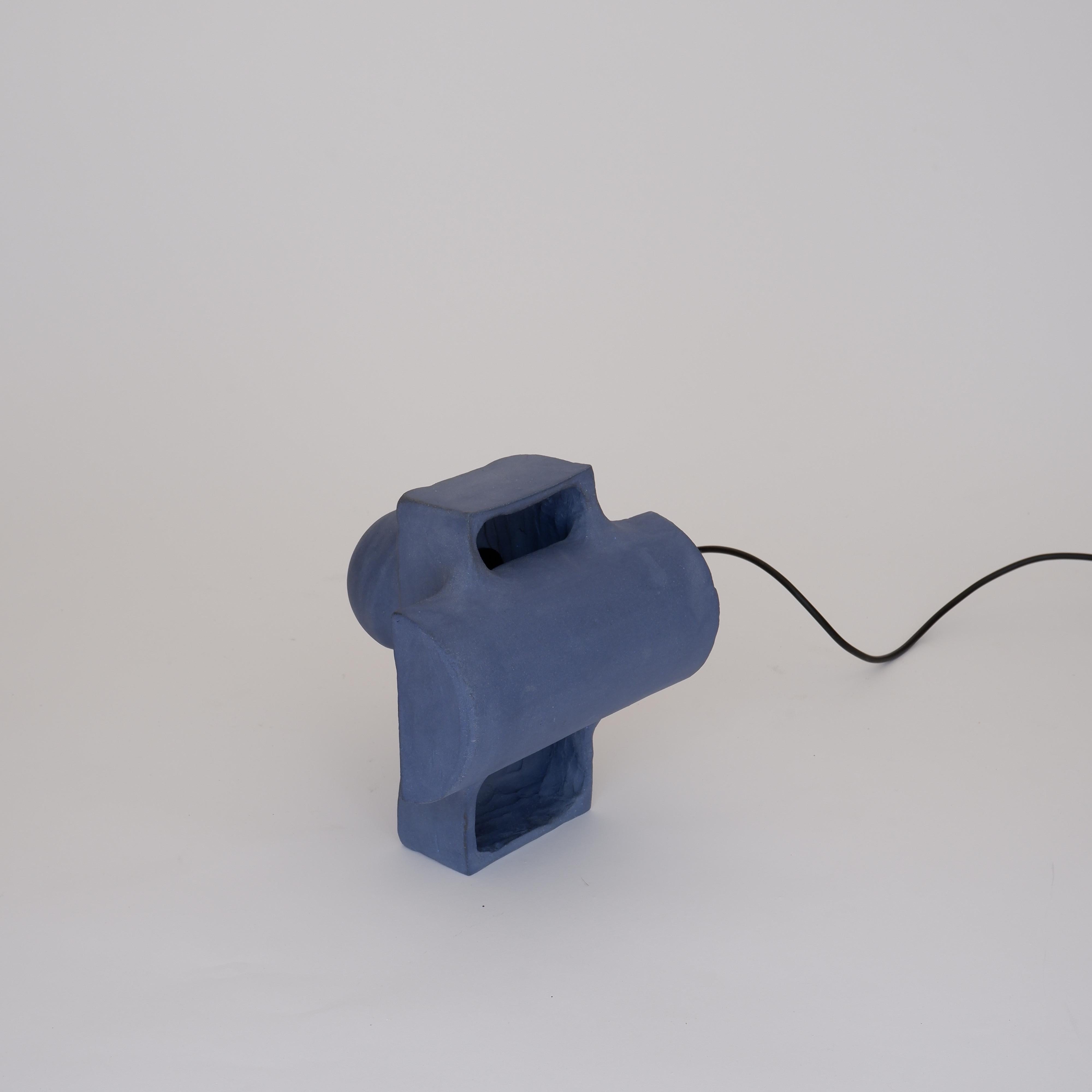 Accre Small Blue Lamp by Ia Kutateladze
One Of A Kind.
Dimensions: D 20 x W 23 x H 22 cm.
Materials: Clay.

Each piece is one of a kind, due to its free hand-building process. Different color variations available: raw black clay, raw white clay, raw