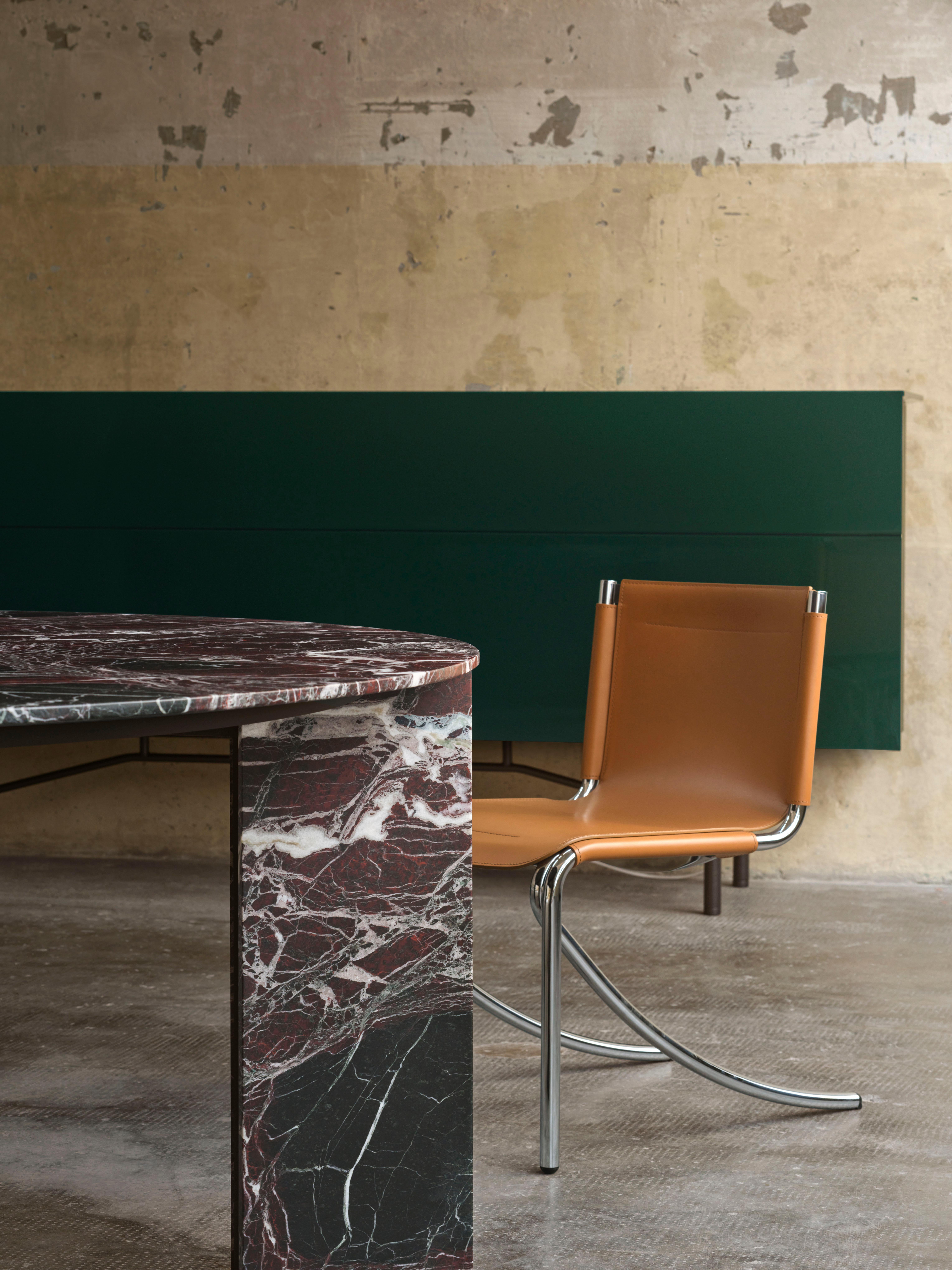 Large table, made of stone and metal. Top of stone thick cm 2 with tapered edges, divided into sections, supported by a wooden panel. Particularly shaped legs with a ''V'' section made of an innovative and contrasting material combination of stone