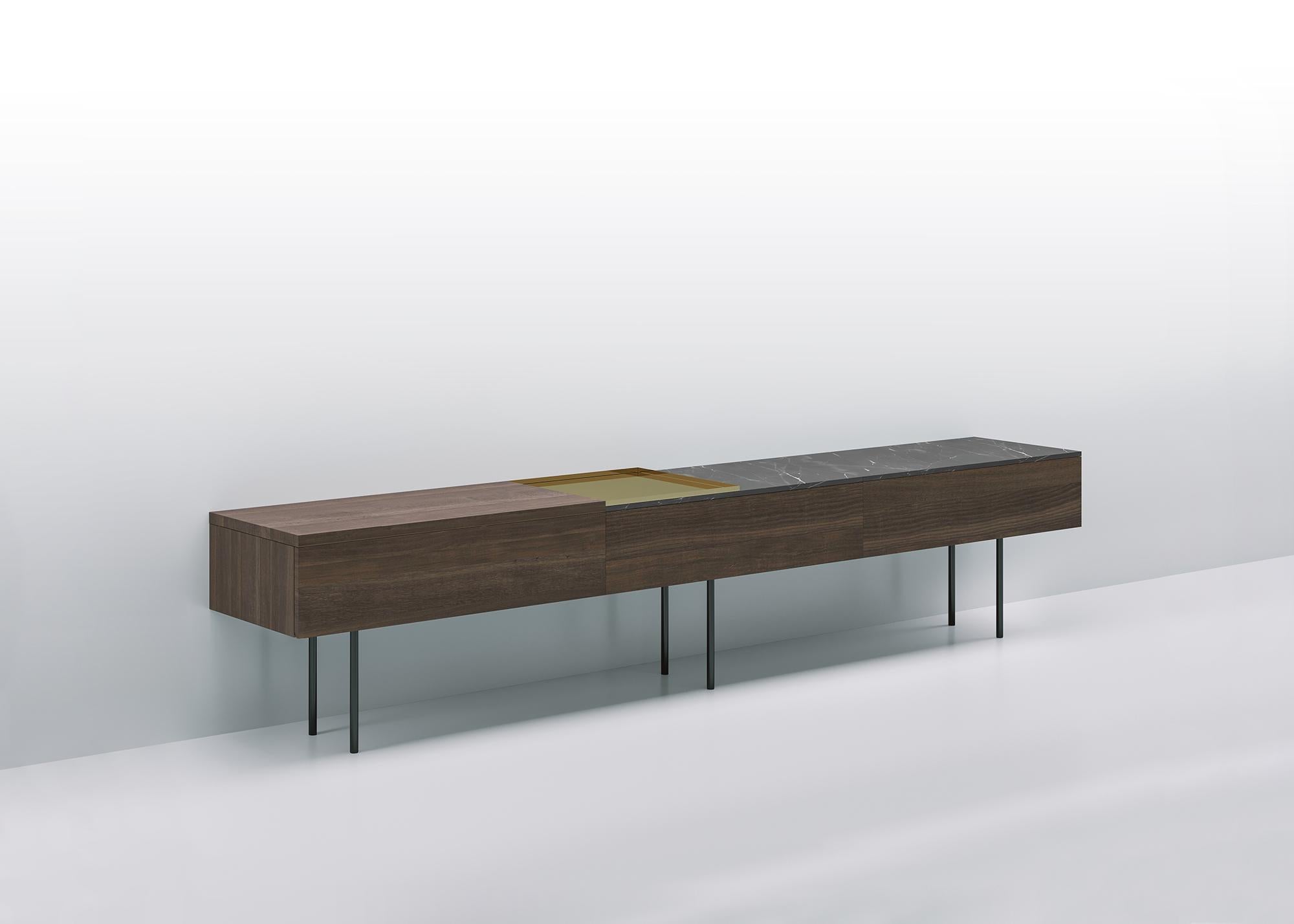 Low modular console resting on a structure of volumes and shelves in different contrasting materials: wood, marble, shiny metals, giving life to compositions in which full and empty volumes and materials differing by type, color nuances, texture and