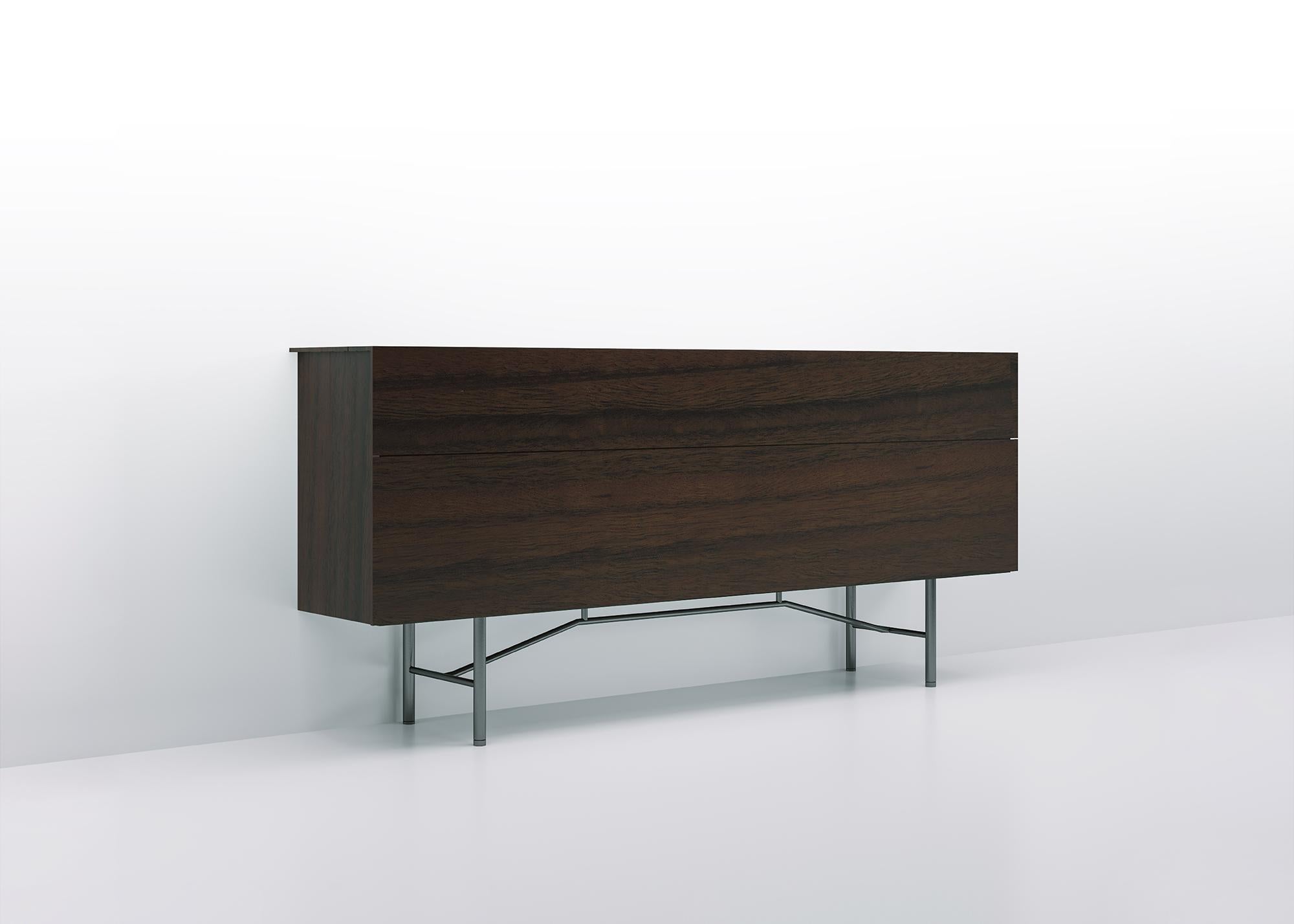 Particularly high buffet, of great storage capacity, characterized by the unusual horizontal division into two compartments with different heights, closed by two large flap doors of finely tapered edges. The upper compartment adopts an evolution of