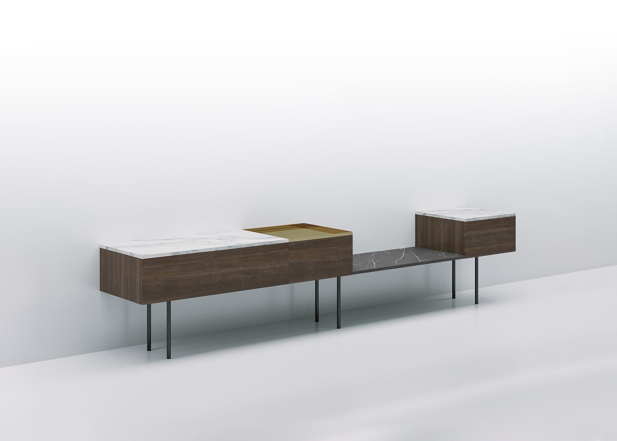Niedrige modulare Konsole, die auf einer Struktur aus Volumen und Regalen aus verschiedenen kontrastierenden Materialien ruht: Holz, Marmor, glänzende Metalle. So entstehen Kompositionen, in denen sich volle und leere Volumen und Materialien