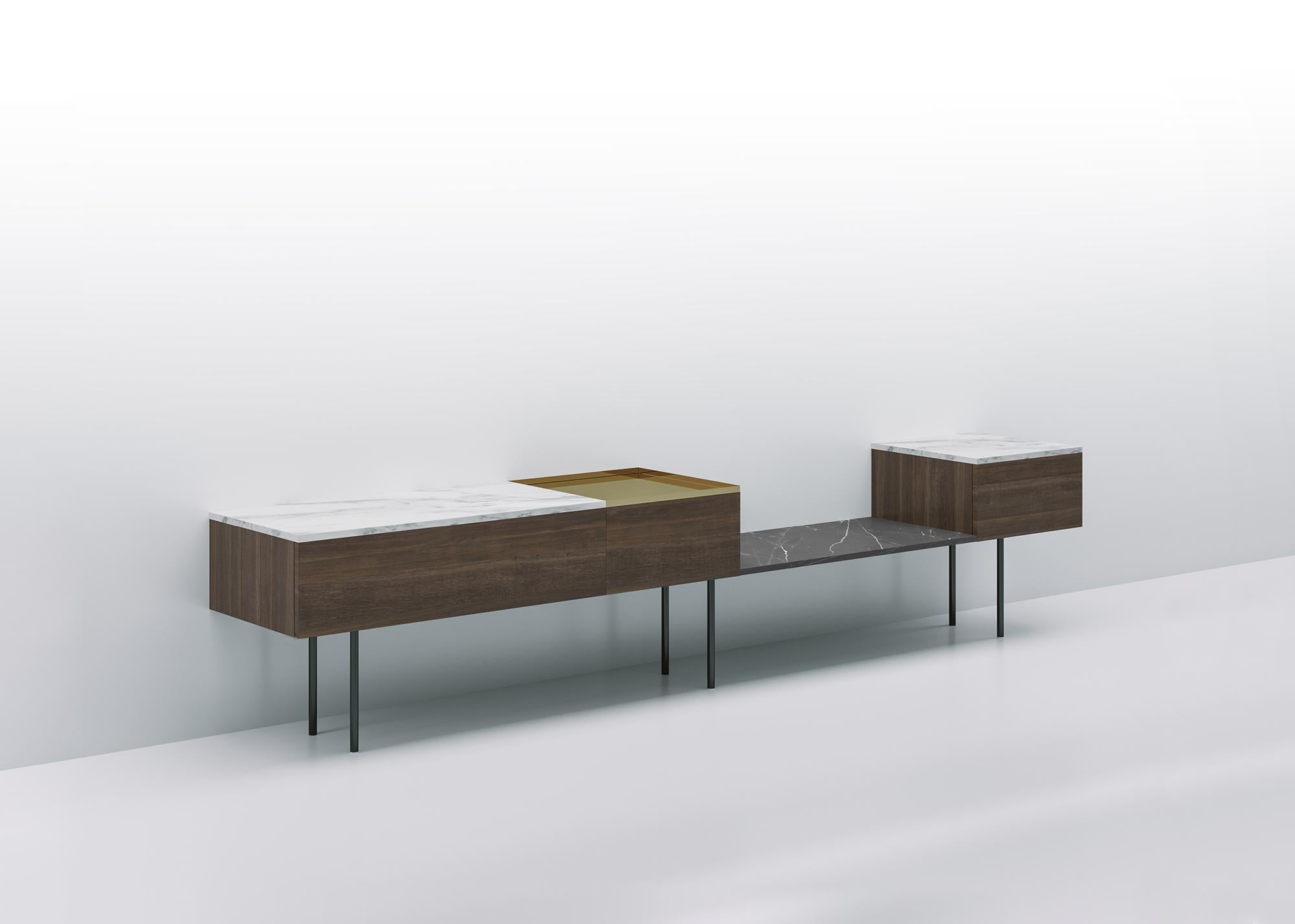 Low modular console resting on a structure of volumes and shelves in different contrasting materials: wood, marble, shiny metals, giving life to compositions in which full and empty volumes and materials differing by type, color nuances, texture and