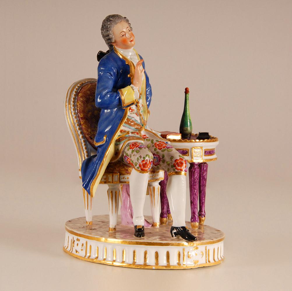 Groupe de sculptures figuratives en porcelaine de Paris
Représentation d'un noble français assis à côté d'une table sur laquelle se trouvent une bouteille et un livre
Pièce très expressive
Fabriqué à la main et émaillé de couleurs vives
Une