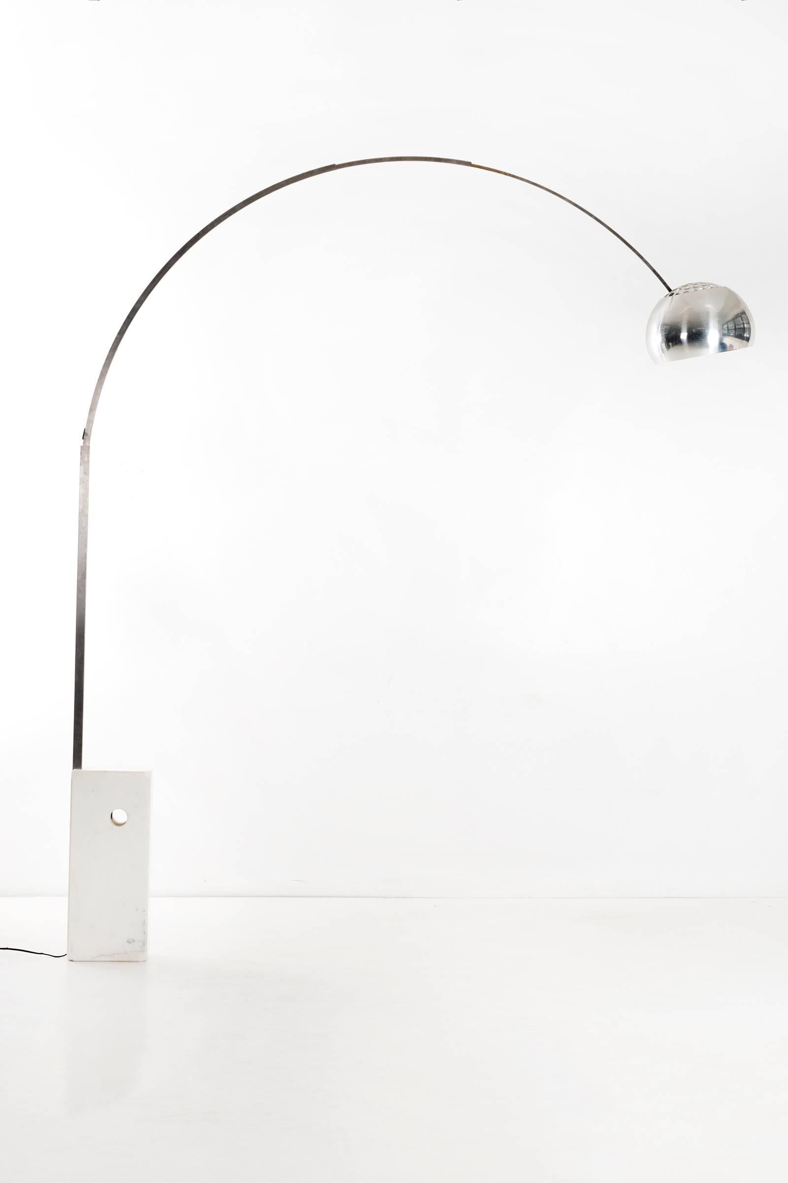 Arco floor lamp (1962). Inspired by a streetlight, the Arco cleverly provides overhead lighting without requiring ceiling suspension, its polished shade extending nearly seven feet to accommodate a dining table or sofa beneath the light source.