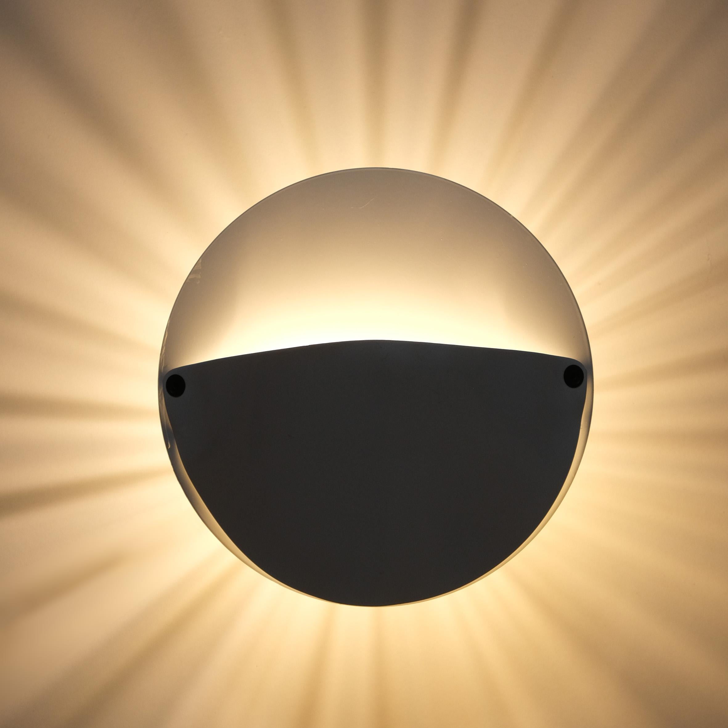 Ein Paar runde Wandleuchten aus weiß lackiertem Metall mit strahlender Hintergrundbeleuchtung.
Produziert von Flos, Italien.
1982.

Literatur
Domus n°646, Januar 1984, S.123

Domus n°654, 1984, S.151

Ottagono 80, März 1986, S. 14-15

Sergio Polano,