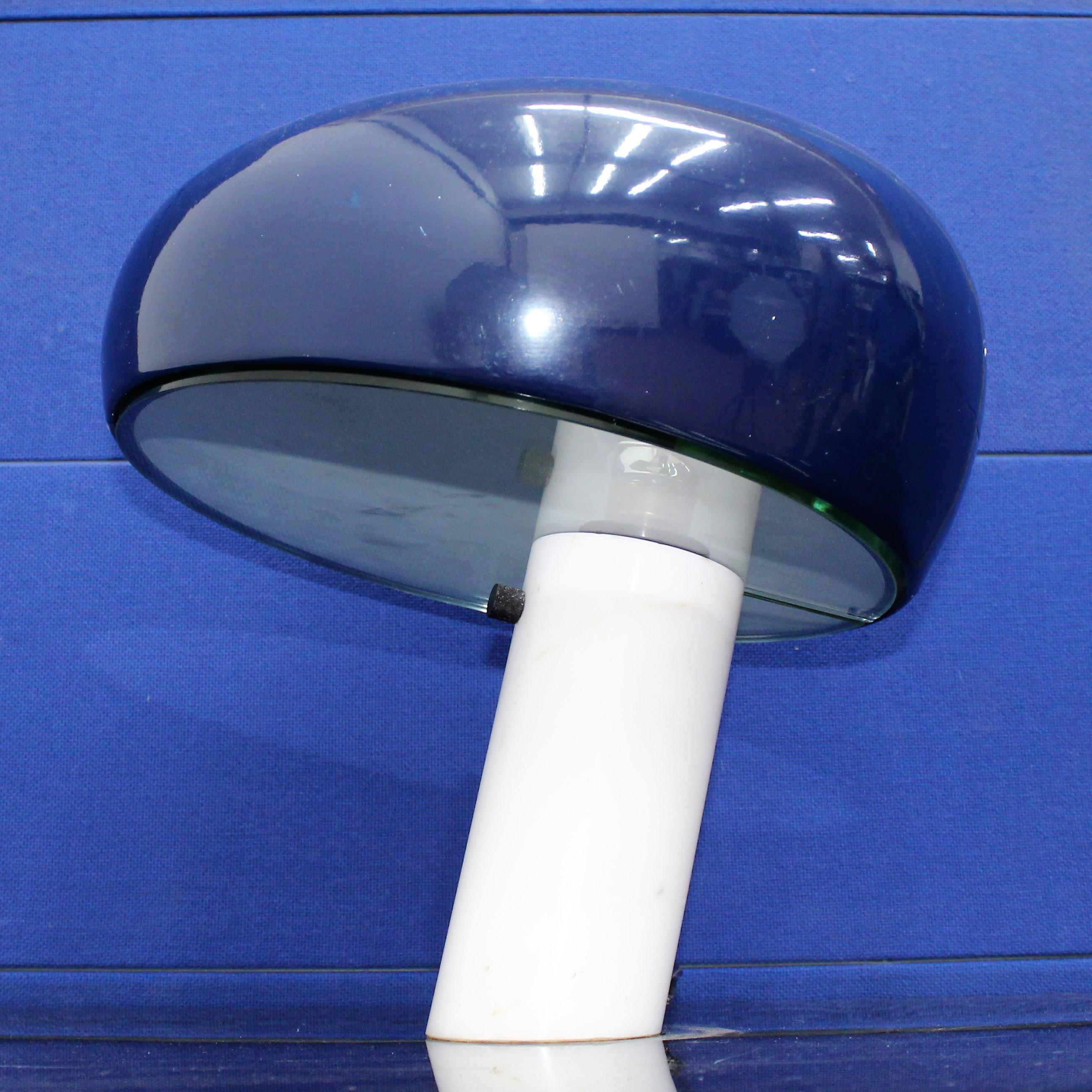 Lampe de table avec une base en marbre blanc et un plateau en métal bleu. La position angulaire de la base et l'abat-jour en forme de champignon donnent à cette pièce un aspect ludique. La lampe est bien détaillée:: et la partition de lumière dans
