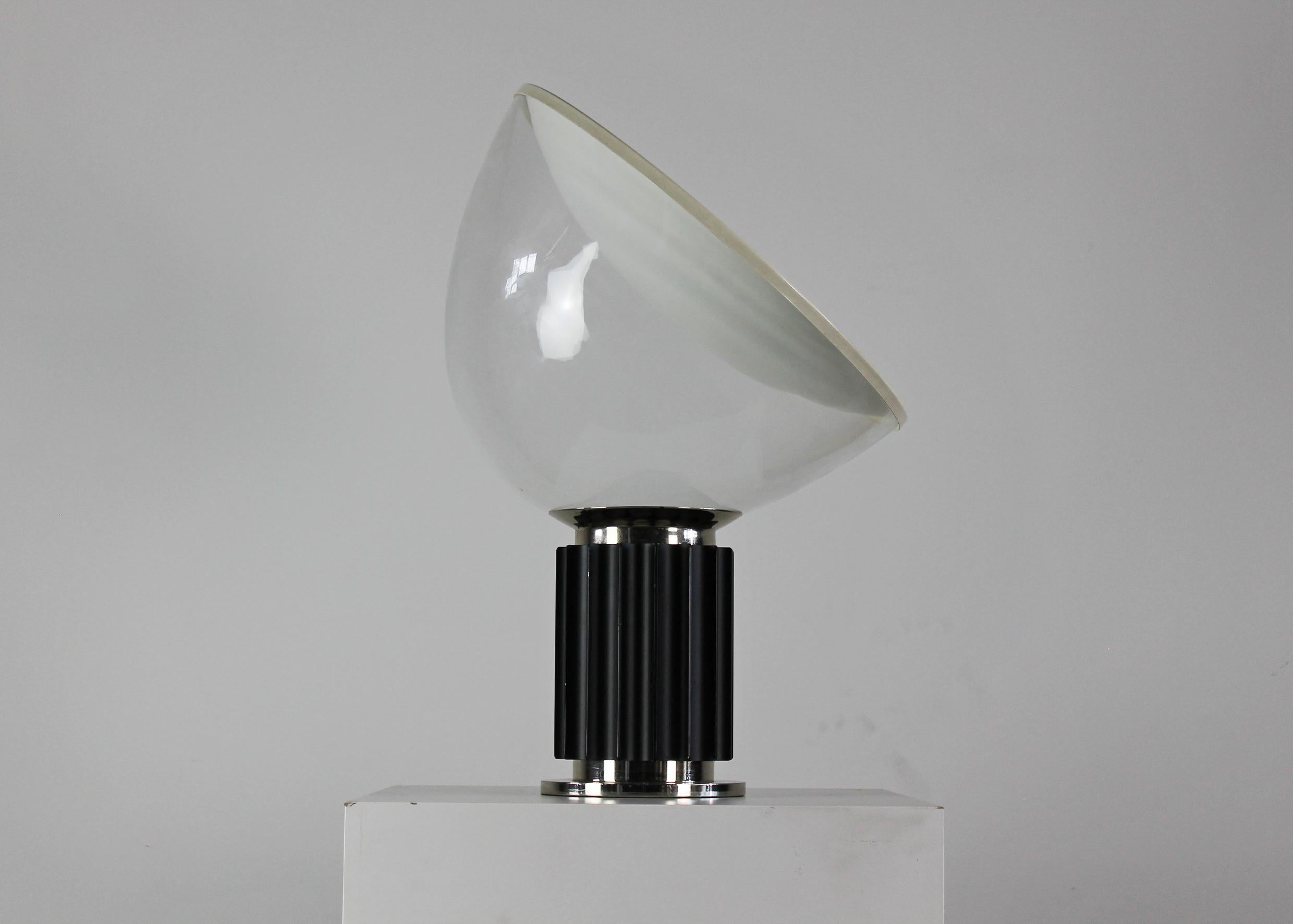 Taccia table lamp with a base realized in cast aluminum and chromed brass, lampshade in blown glass, and white lacquered aluminum designed by Achille and Pier Giacomo Castiglioni in 1962 for Flos, Italy.

The manufacturer's label is visible inside